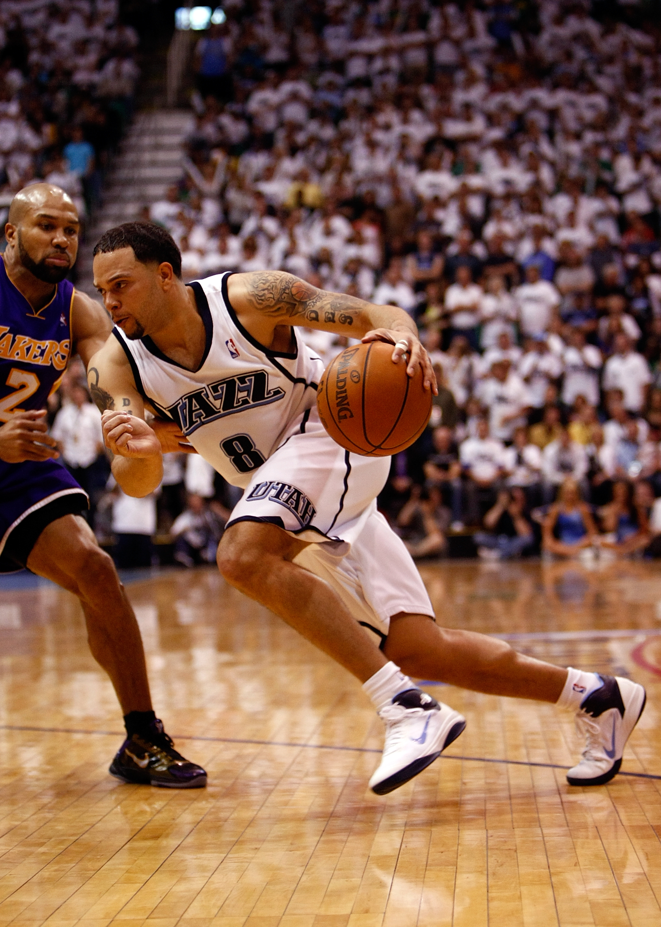 SALT LAKE CITY - MAY 08:  Deron Williams #8 of the Utah Jazz drives by Derek Fisher #2 of the Los Angeles Lakers during Game Three of the Western Conference Semifinals of the 2010 NBA Playoffs on May 8, 2010 at Energy Solutions Arena in Salt Lake City, Ut