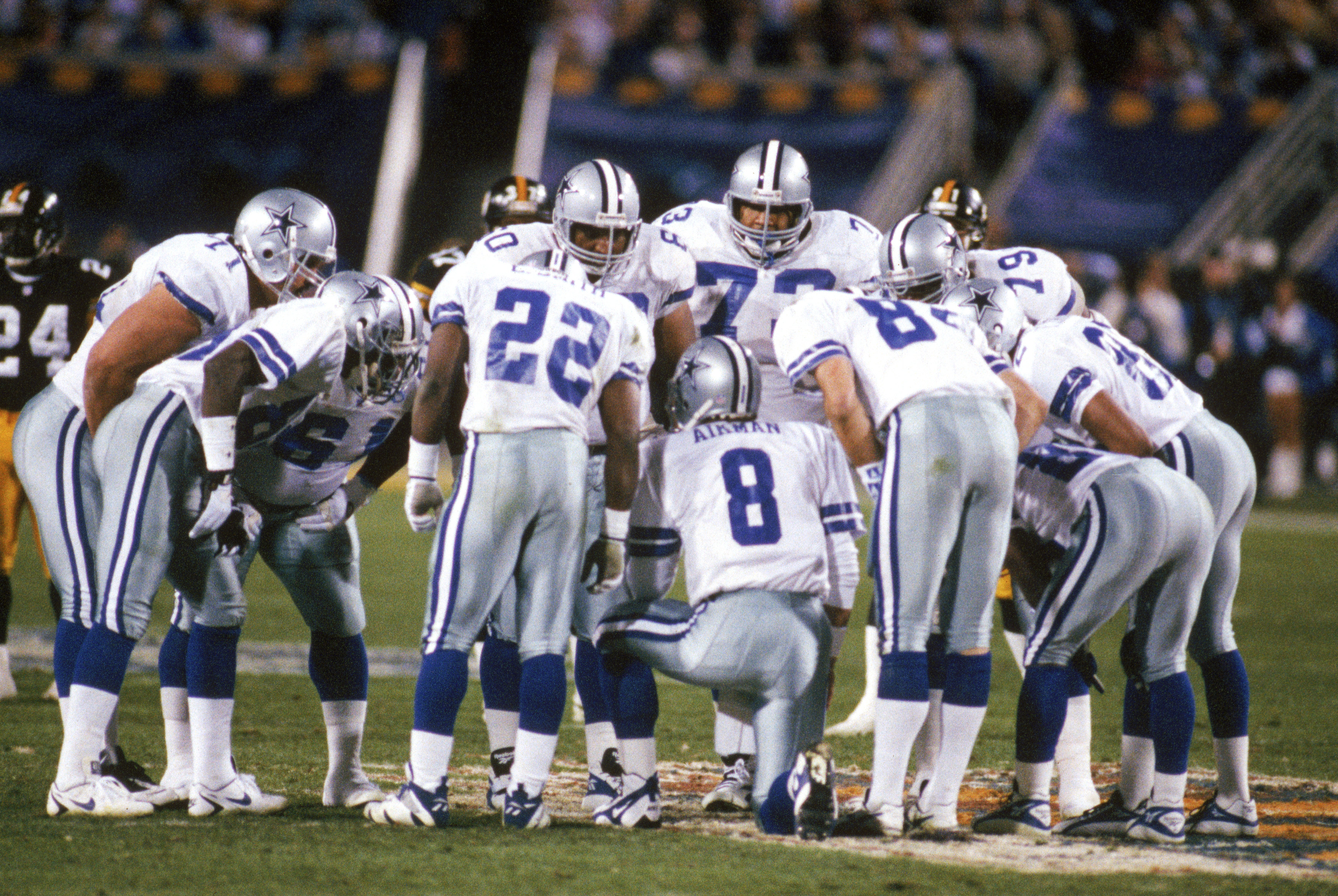 TEMPE, AZ - JANUARY 28:  Quarterback Troy Aikman #8 of the Dallas Cowboys leads his team in a huddle during Super Bowl XXX against the Pittsburgh Steelers at Sun Devil Stadium on January 28, 1996 in Tempe, Arizona.  The Cowboys won 27-17.  (Photo by Georg