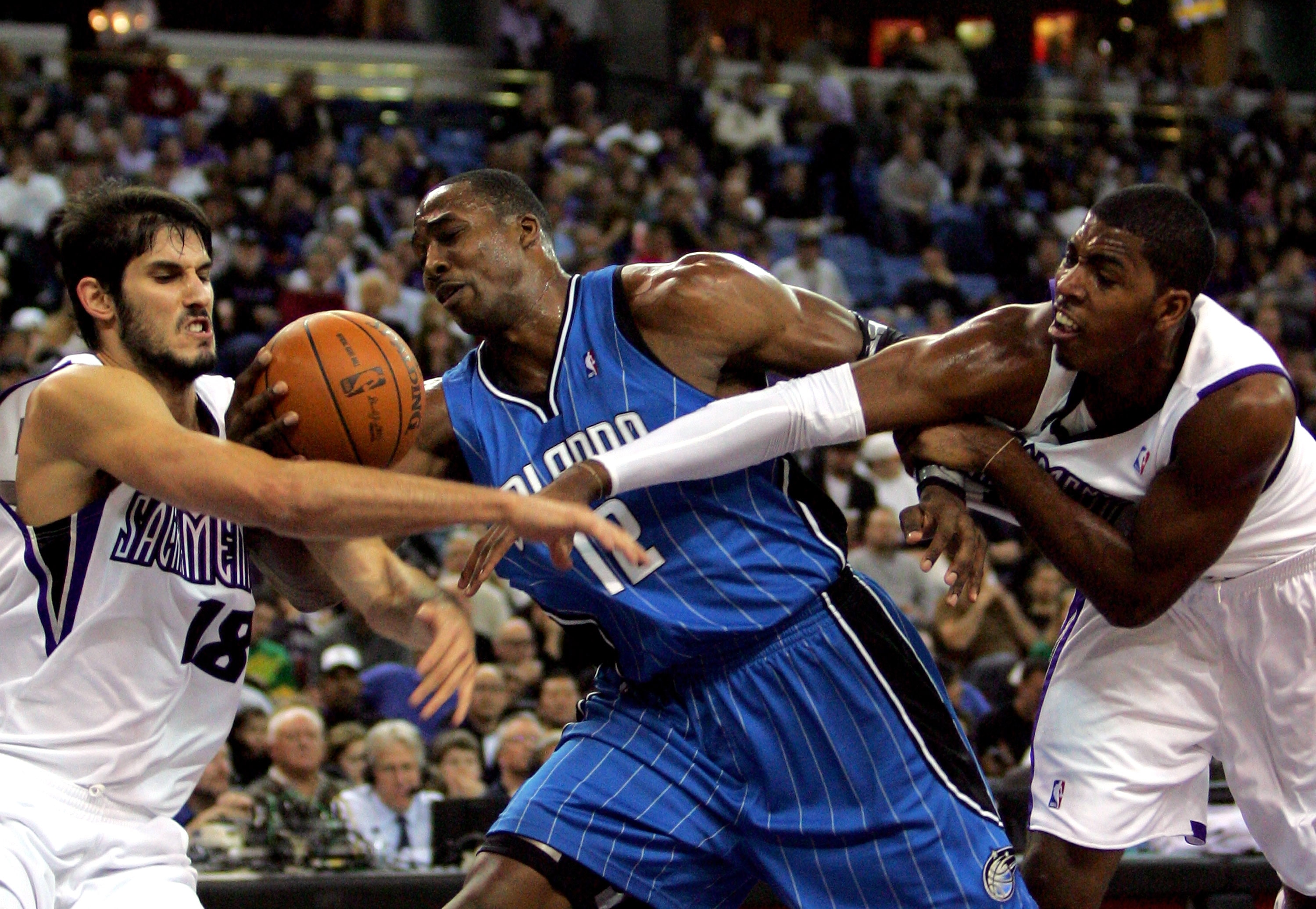 SACRAMENTO, CA - JANUARY 12: Dwight Howard #12 of the Orlando Magic gets tangled with Omri Casspi #18 and Jason Thompson #34 of the Sacramento Kings at ARCO Arena on January 12, 2010 in Sacramento, California. NOTE TO USER: User expressly acknowledges a