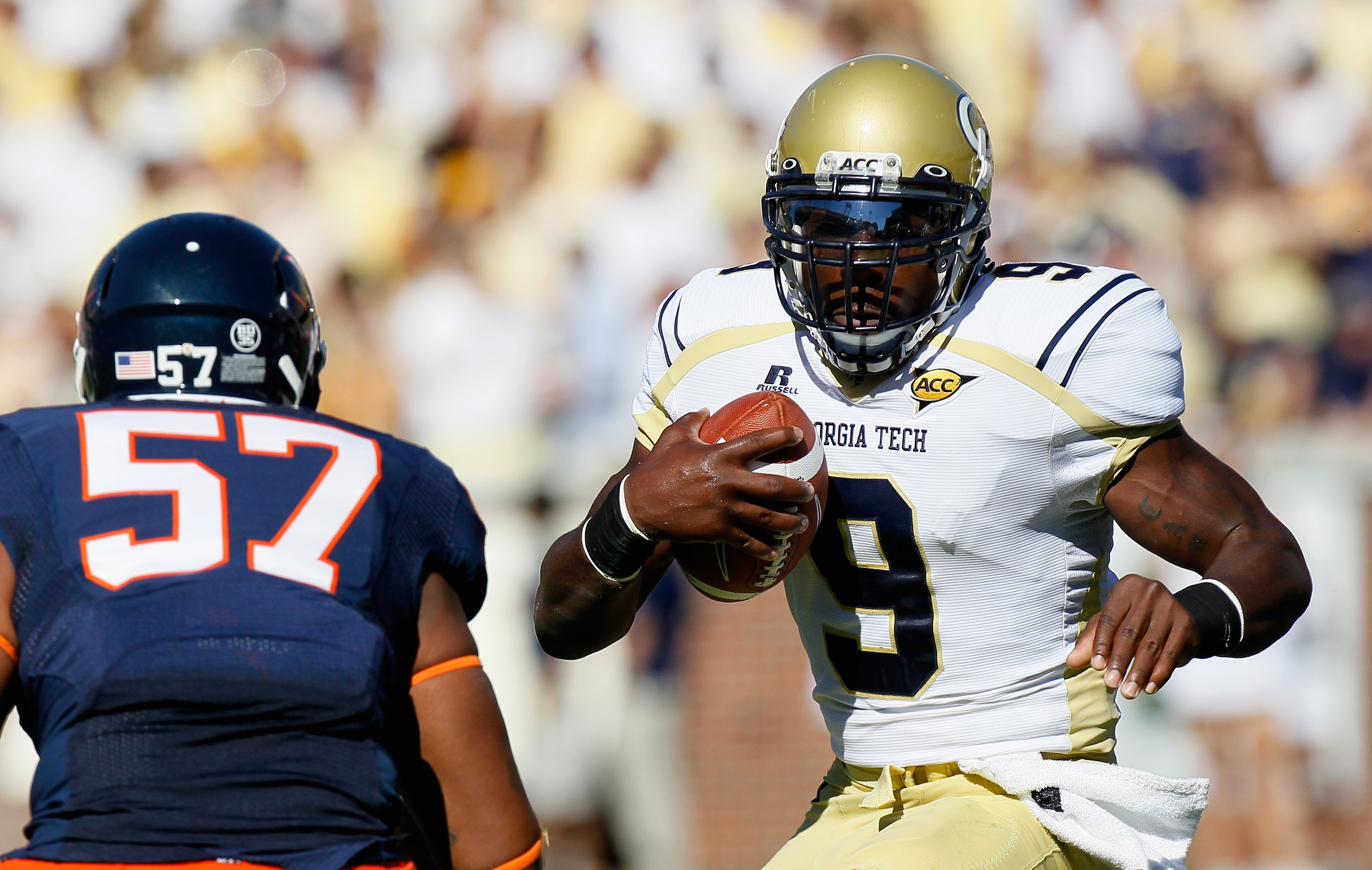 ATLANTA - OCTOBER 09: Quarterback Joshua Nesbitt #9 of the Georgia Tech Yellow Jackets rushes upfield at Darnell Carter #57 of the Virginia Cavaliers at Bobby Dodd Stadium on October 9, 2010 in Atlanta, Georgia. (Photo by Kevin C. Cox/Getty Images)