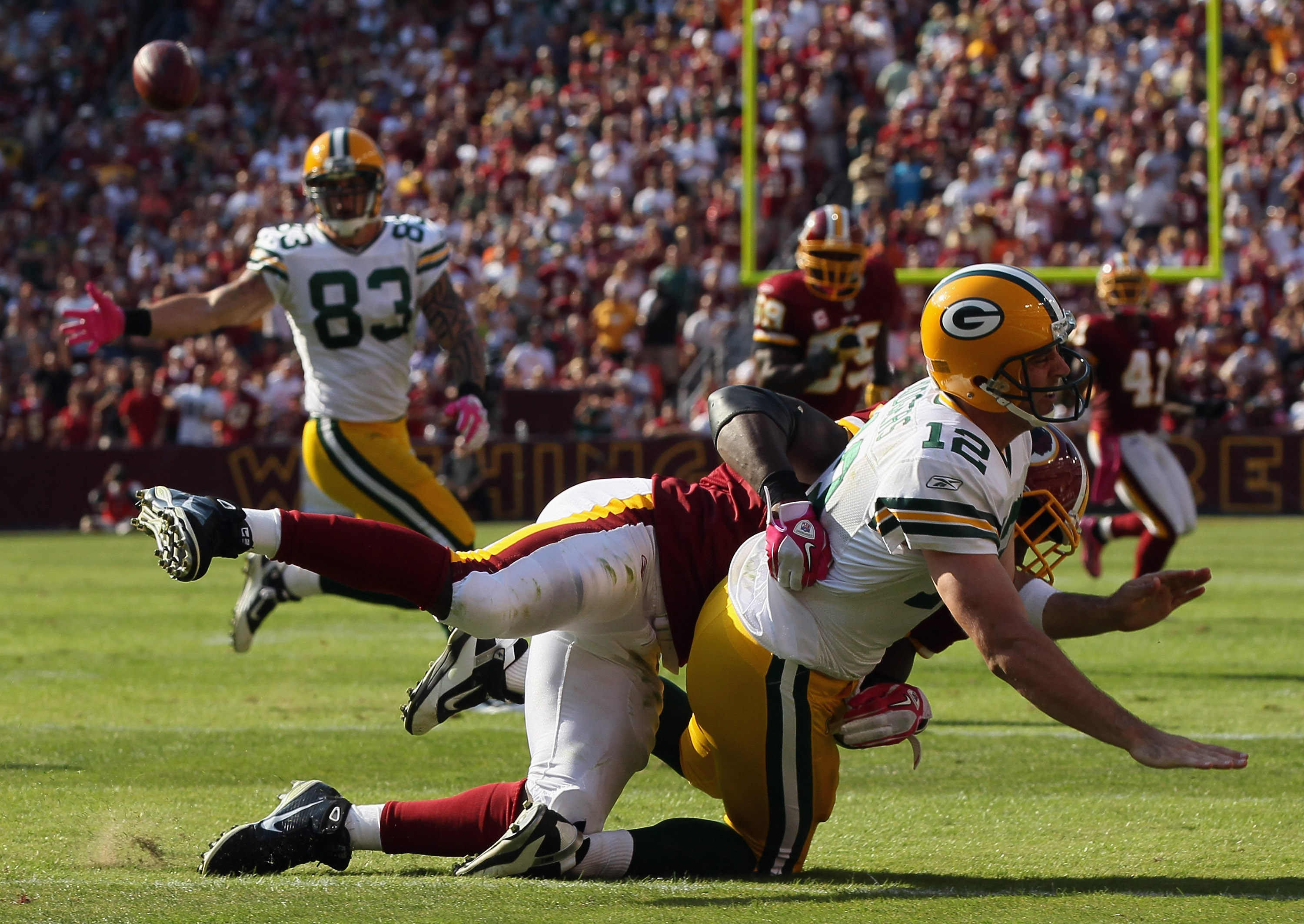 LANDOVER, MD - OCTOBER 10:  Quarterback Aaron Rodgers #12 of the Green Bay Packers is taken to the ground by lineback Brian Orakpo #98 of the Washington Redskins in the fourth quarter at FedExField on October 10, 2010 in Landover, Maryland. The Redskins w