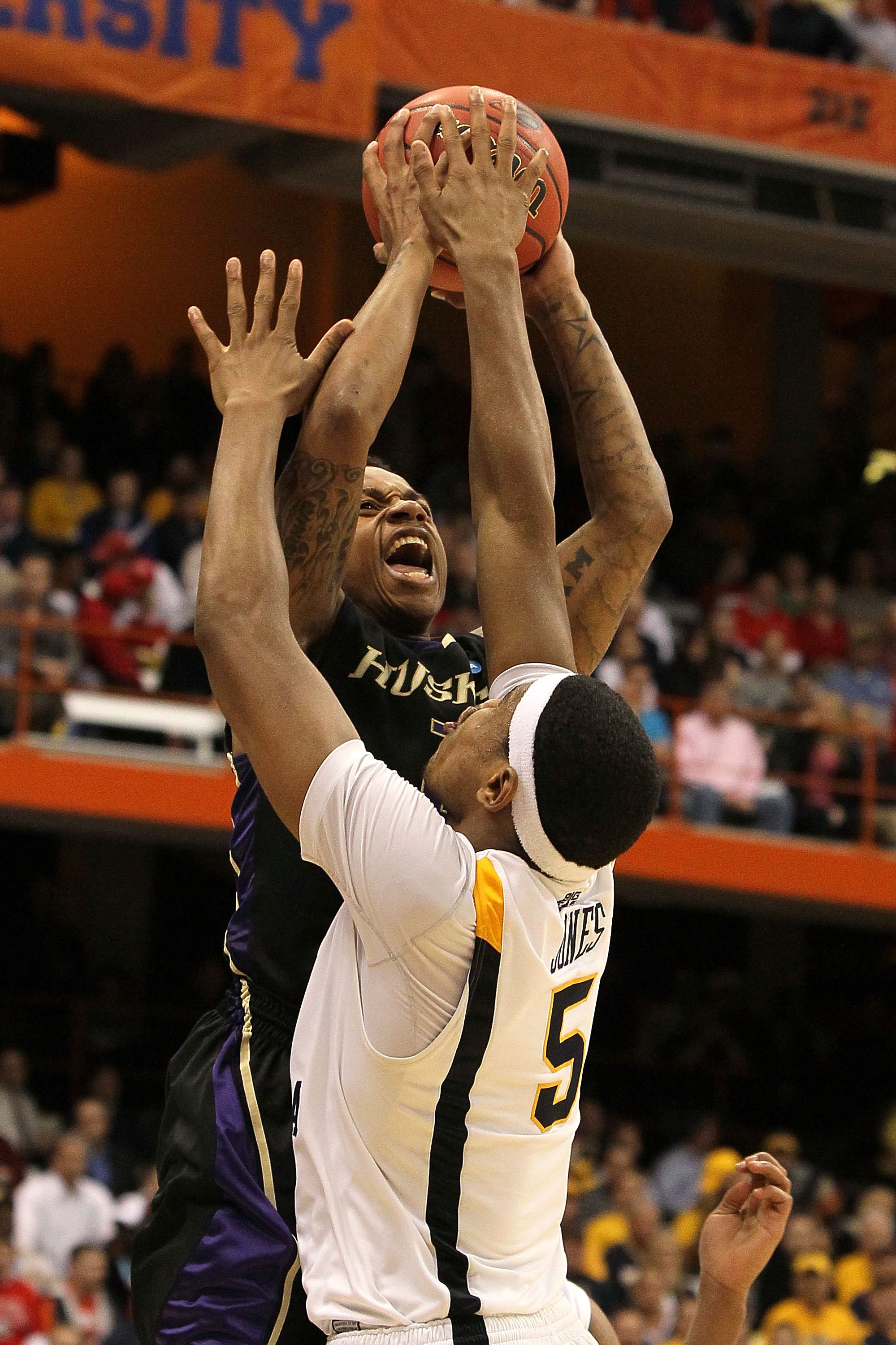 SYRACUSE, NY - MARCH 25: Isaiah Thomas #2 of the Washington Huskies attempts a shot against Kevin Jones #5 of the West Virginia Mountaineers during the east regional semifinal of the 2010 NCAA men's basketball tournament at the Carrier Dome on March 25,