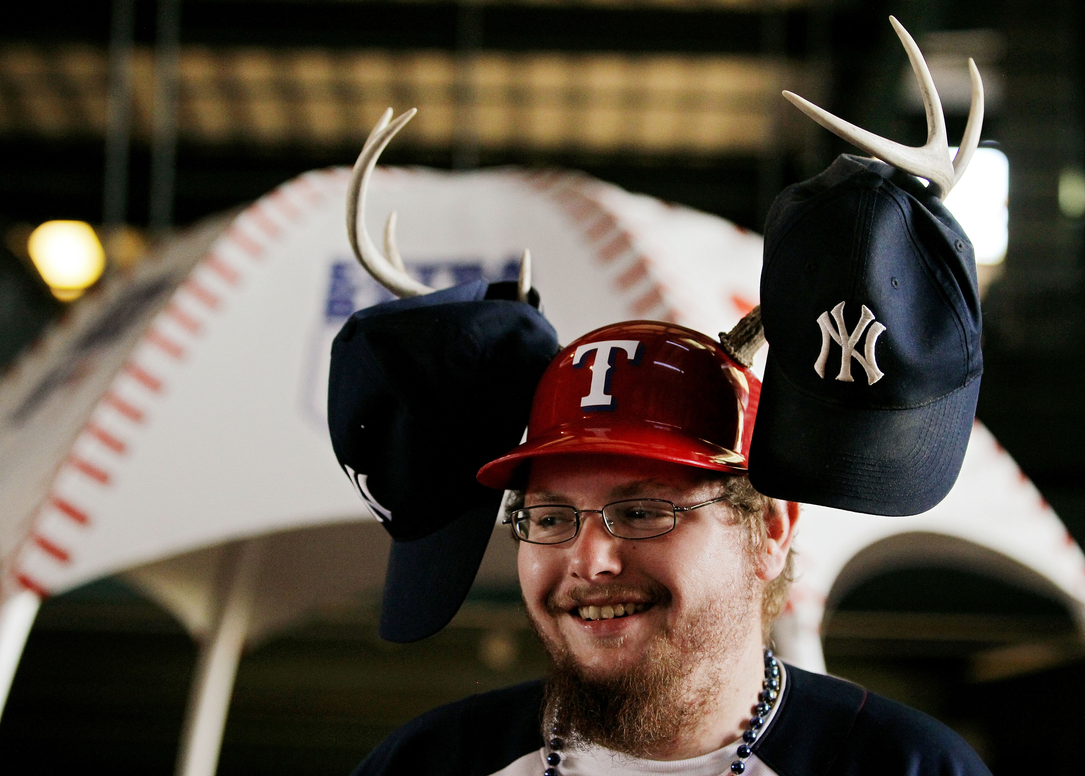 ARLINGTON, TX - OCTOBER 15:  A fan of the Texas Rangers wears a helmet with antlers on it with Yankees hats attached to it before Game One of the ALCS during the 2010 MLB Playoffs at Rangers Ballpark in Arlington on October 15, 2010 in Arlington, Texas.