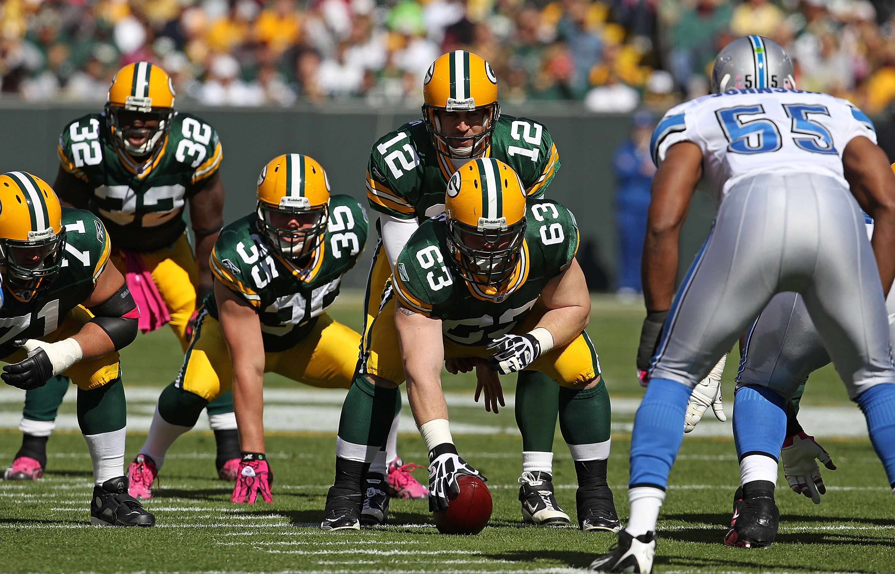 GREEN BAY, WI - OCTOBER 03: Aaron Rodgers #12 of the Green Bay Packers calls the signals as teammates Brandon Jackson #32, Korey Hall #35 and Scott Wells #63 await the snap while Landon Johnson #55 of the Detroit Lions watches at Lambeau Field on October
