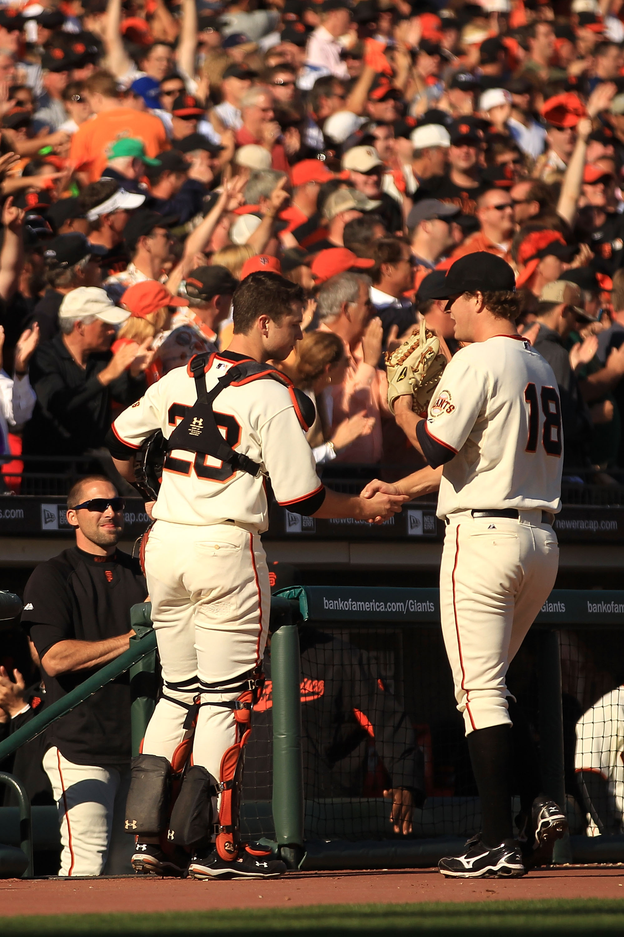 SAN FRANCISCO - OCTOBER 19:  Buster Posey #28 of the San Francisco Giants shakes hands with Matt Cain #18 in the middle of the seventh inning of Game Three of the NLCS against the Philadelphia Phillies during the 2010 MLB Playoffs at AT&T Park on October
