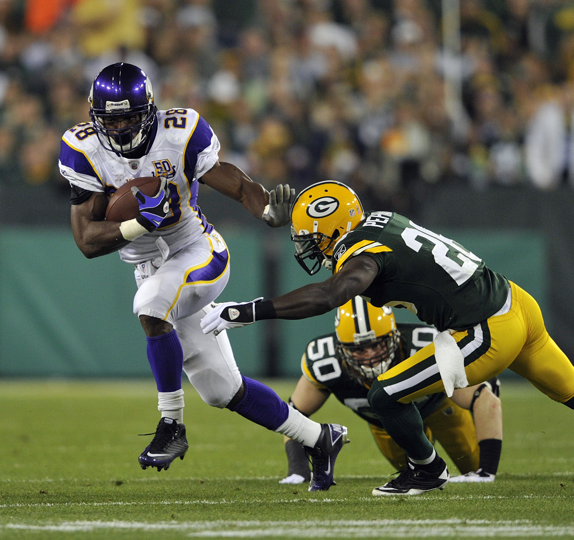 GREEN BAY, WI - OCTOBER 24:  Adrian Peterson #28 of the Minnesota Vikings runs upfield as Charlie Peprah #26 of the Green Bay Packers misses the tackle at Lambeau Field on October 24, 2010 in Green Bay, Wisconsin. (Photo by Jim Prisching/Getty Images)