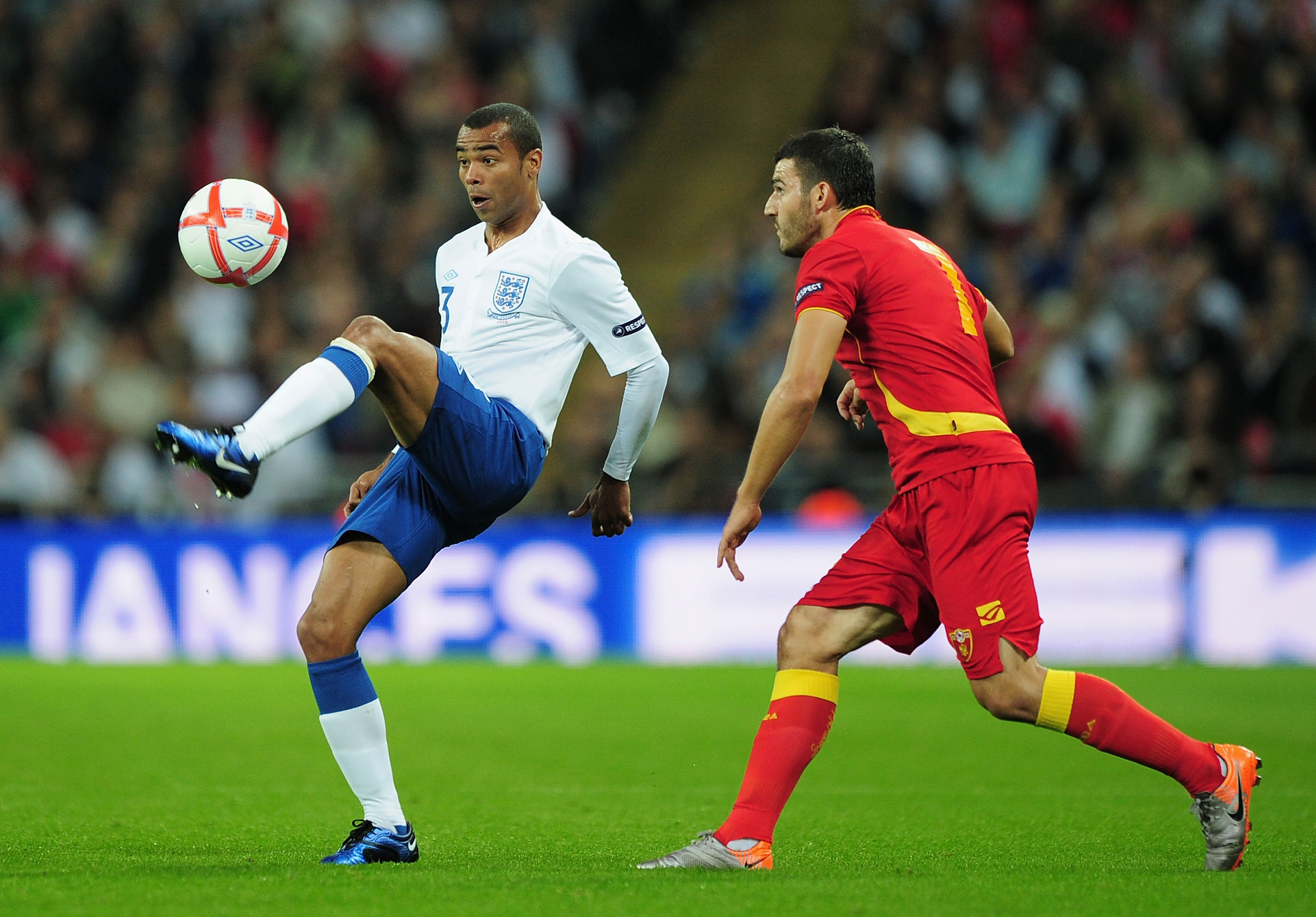 LONDON, ENGLAND - OCTOBER 12: Ashley Cole of England and Simon Vukcevic of Montenegro during the UEFA EURO 2012 Group G Qualifying match between England and Montenegro at Wembley Stadium on October 12, 2010 in London, England.  (Photo by Shaun Botterill/G
