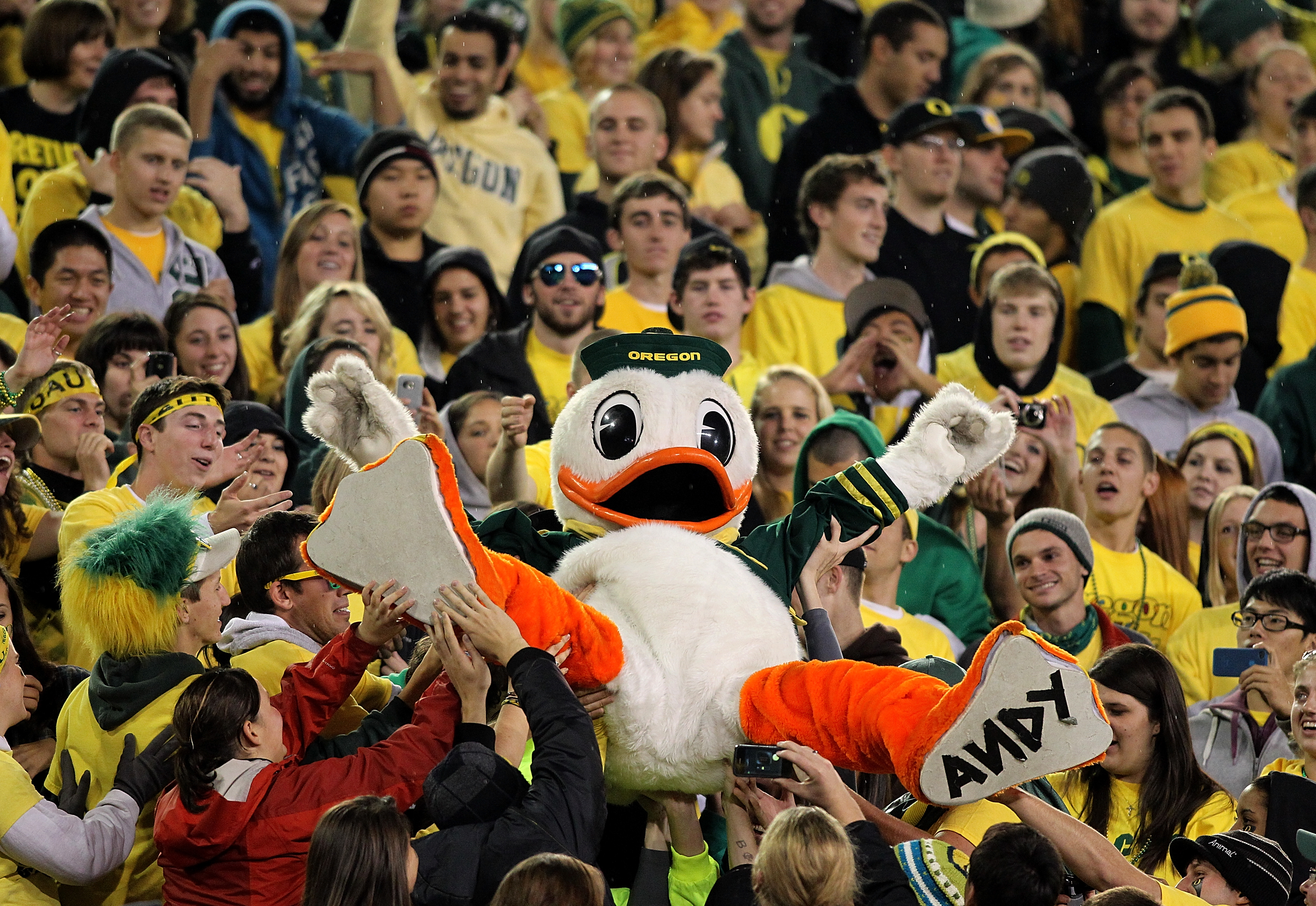 EUGENE, OR - OCTOBER 21:  The Oregon Duck mascot is lifted into the crowd during the game against the UCLA Bruins  on October 21, 2010 at the Autzen Stadium in Eugene, Oregon.  (Photo by Jonathan Ferrey/Getty Images)