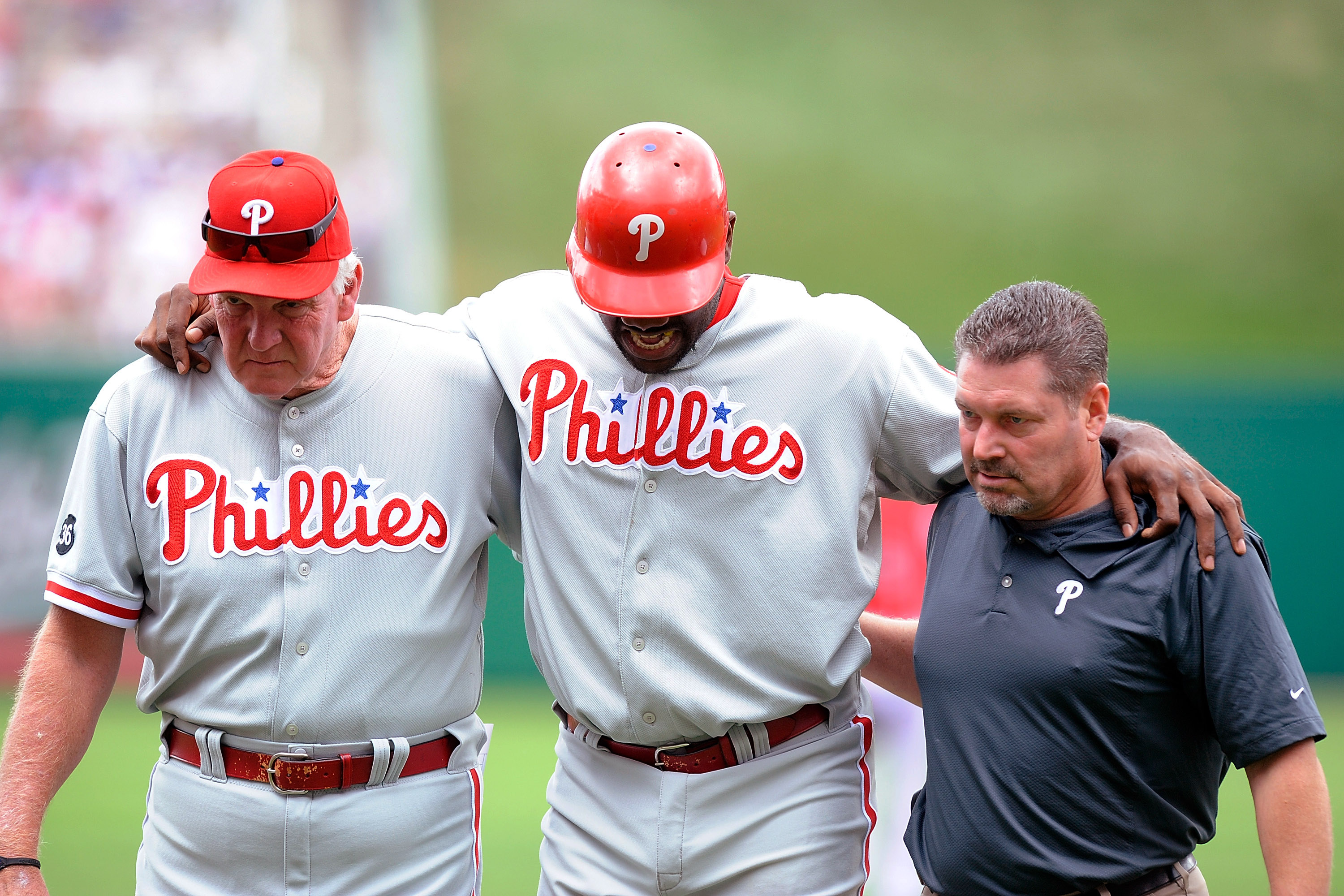 WASHINGTON - AUGUST 01:  Ryan Howard #6 of the Philadelphia Phillies is helped off the field by manager Charlie Manuel and a Philadelphia trainer after injuring his ankle during the first inning against the Washington Nationals at Nationals Park on August