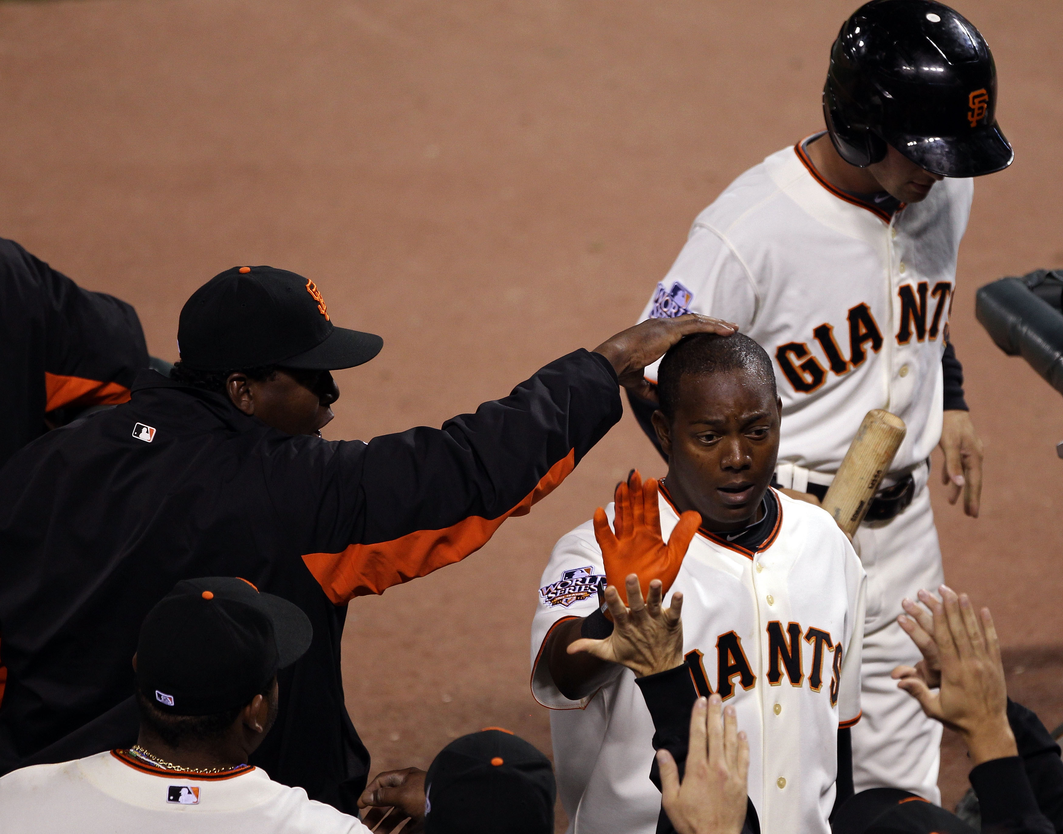 SAN FRANCISCO - OCTOBER 28:  (R) Edgar Renteria #16 of the San Francisco Giants is greeted by teammates in the dugout after scoring a run in the eighth inning taking on the Texas Rangers in Game Two of the 2010 MLB World Series at AT&T Park on October 28,