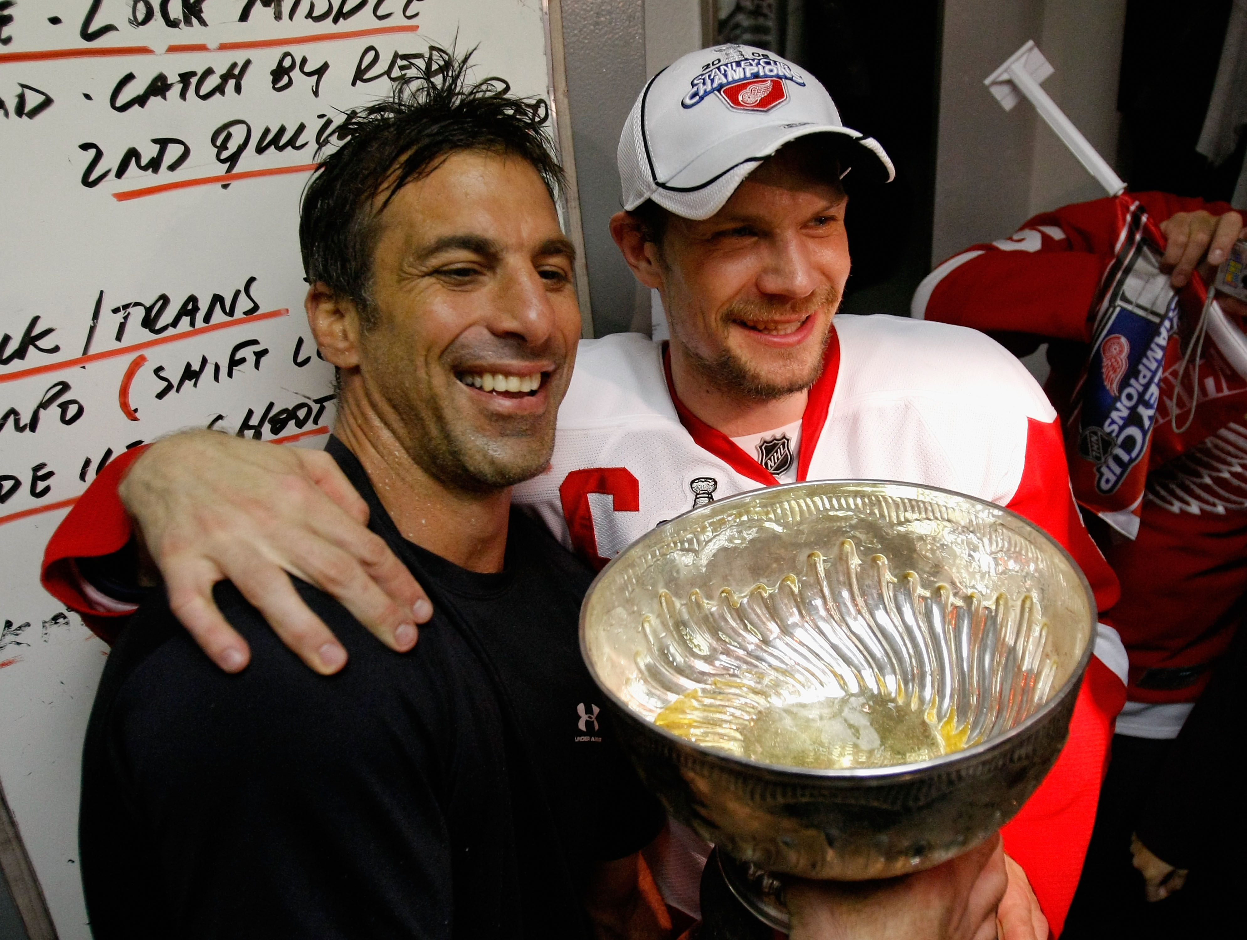 PITTSBURGH - JUNE 04:  Chris Chelios and Nicklas Lidstrom of the Detroit Red Wings celebrate with the Stanley Cup in the locker room after defeating the Pittsburgh Penguins in game six of the 2008 NHL Stanley Cup Finals at Mellon Arena on June 4, 2008 in