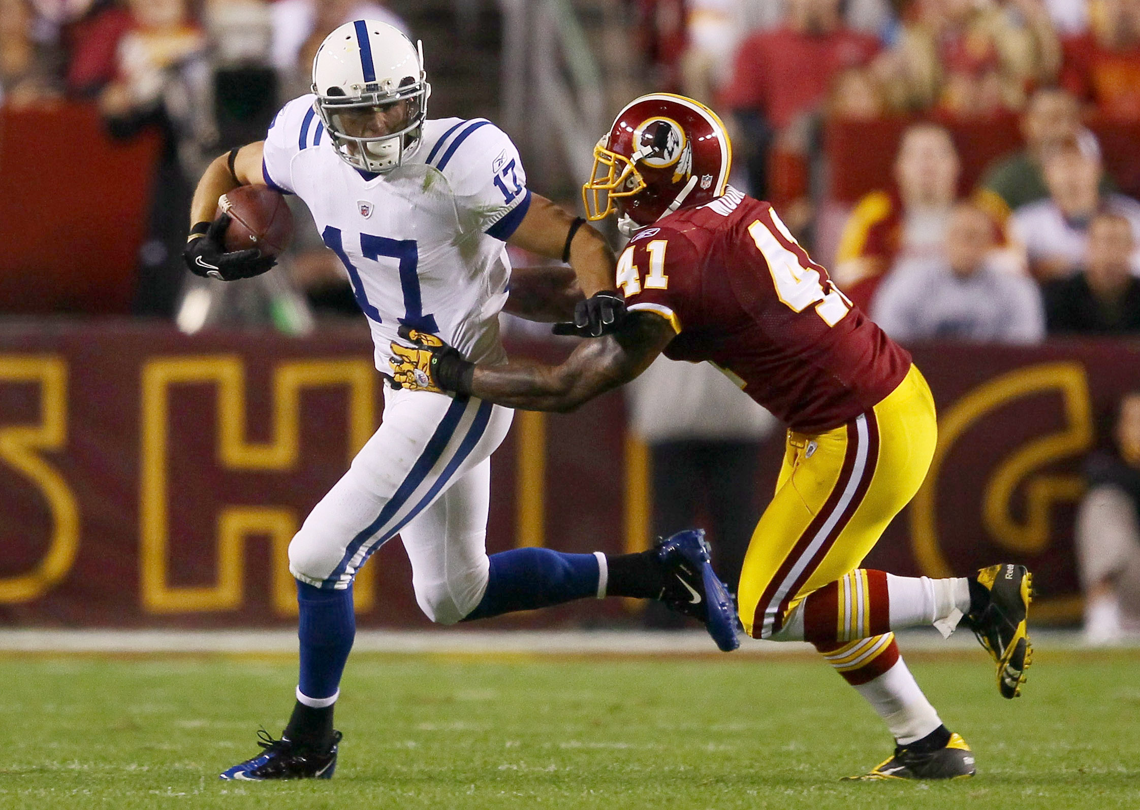 LANDOVER, MD - OCTOBER 17: Austin Collie #17 of the Indianapolis Colts moves the ball upfield after making a reception against Kareem Moore #41 of the Washington Redskins at FedExField on October 17, 2010 in Landover, Maryland.  (Photo by Win McNamee/Gett