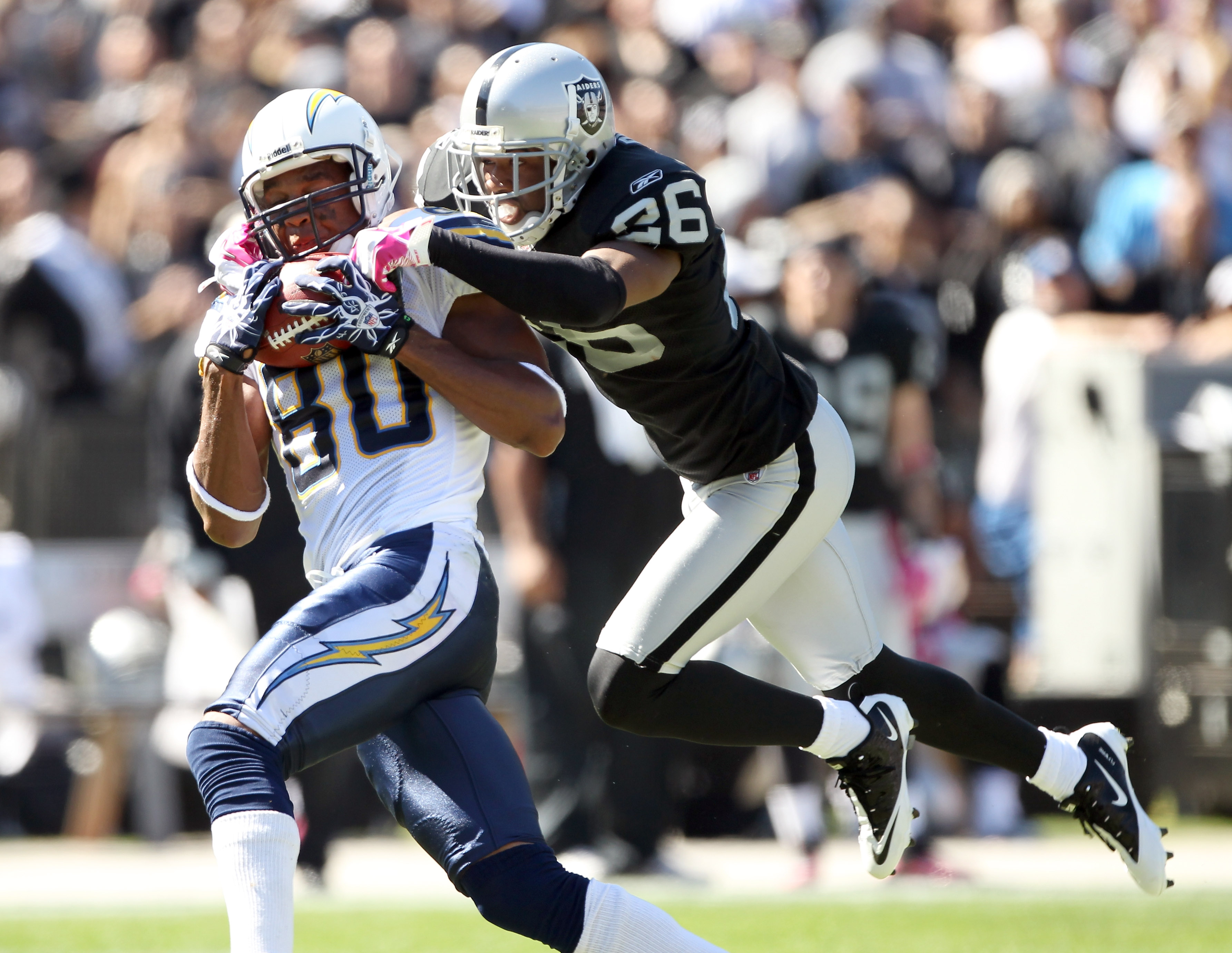 OAKLAND, CA - OCTOBER 10:  Malcom Floyd #80 of the San Diego Chargers catches a ball while defended by Stanford Routt #26 of the Oakland Raiders at Oakland-Alameda County Coliseum on October 10, 2010 in Oakland, California.  (Photo by Ezra Shaw/Getty Imag