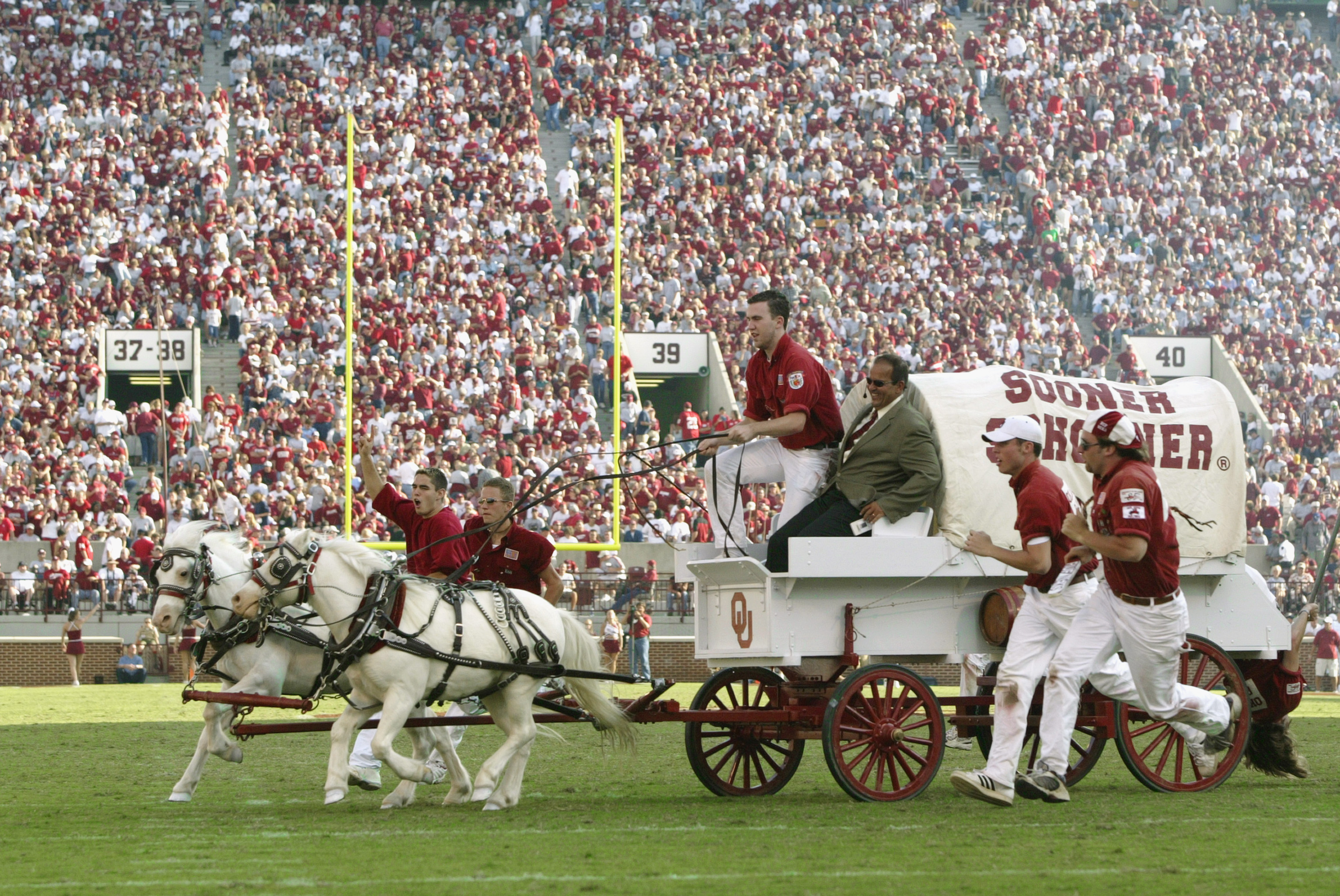 NORMAN, OK - SEPTEMBER 20:  Sideline reporter Jack Arute takes a ride on the University of Oklahoma Sooners Boomer Schooner after a touchdown during a game against the University of California, Los Angeles Bruins at Memorial Stadium on September 20, 2003
