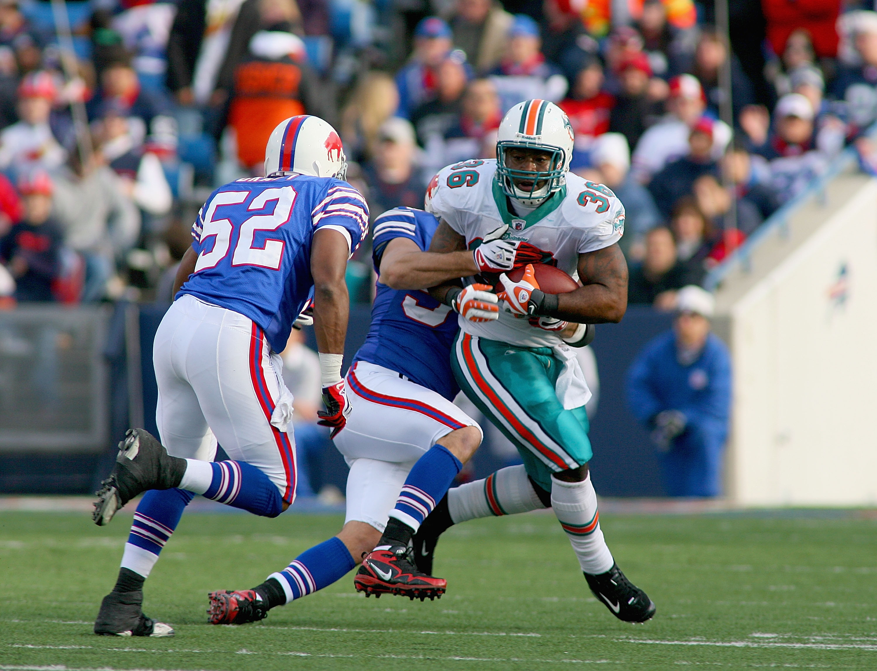 ORCHARD PARK, NY - NOVEMBER 29: Lousaka Polite #36 of the Miami Dolphins runs as Paul Posluszny #51 and Chris Draft #52 of the Buffalo Bills come in to make the tackle at Ralph Wilson Stadium on November 29, 2009 in Orchard Park, New York. Buffalo won 31-