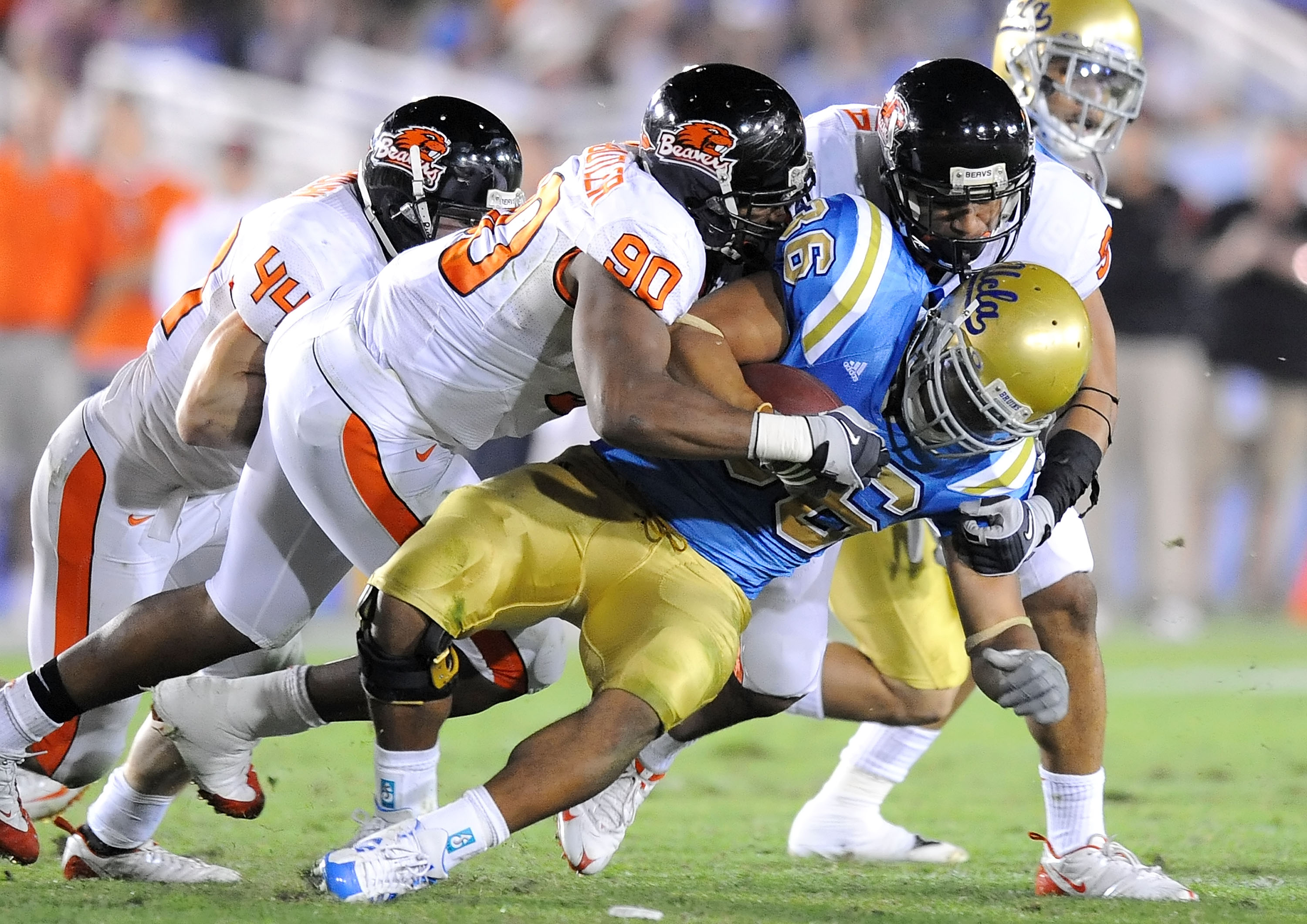 PASADENA, CA - NOVEMBER 08: (L-R)Victor Butler #90 and Al Afalava #9 of the Oregon State Beavers tackle Kahlil Bell #36 of the UCLA Bruins at the Pasadena Rose Bowl on November 8, 2008 in Pasadena, California. (Photo by Lisa Blumenfeld/Getty Images)