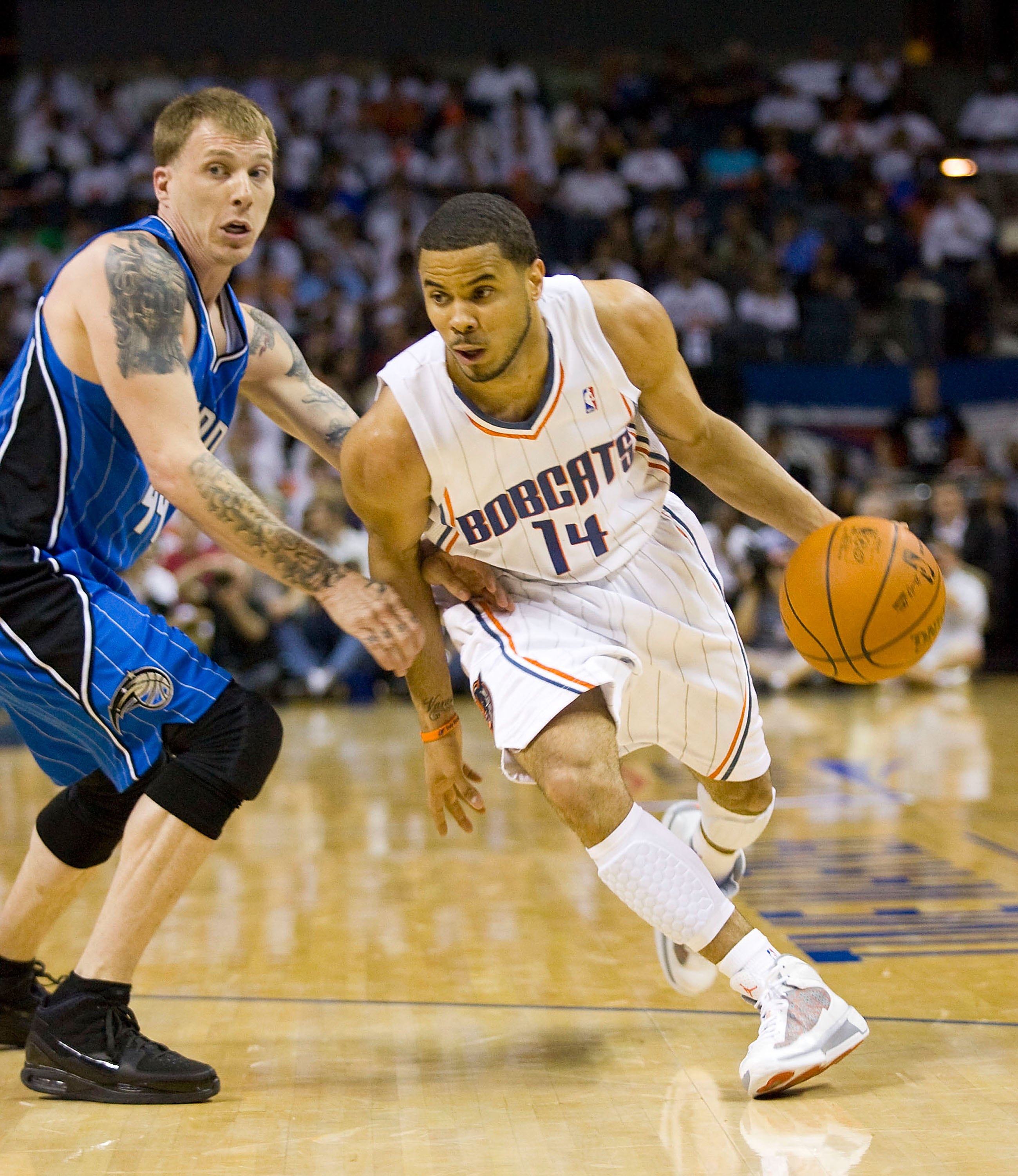 CHARLOTTE, NC - APRIL 26: D.J. Augustin #14 of the Charlotte Bobcats dribbles past Jason Williams #44 of the Orlando Magic at Time Warner Cable Arena on April 26, 2010 in Charlotte, North Carolina.  The Magic defeated the Bobcats 99-90 to complete the fou