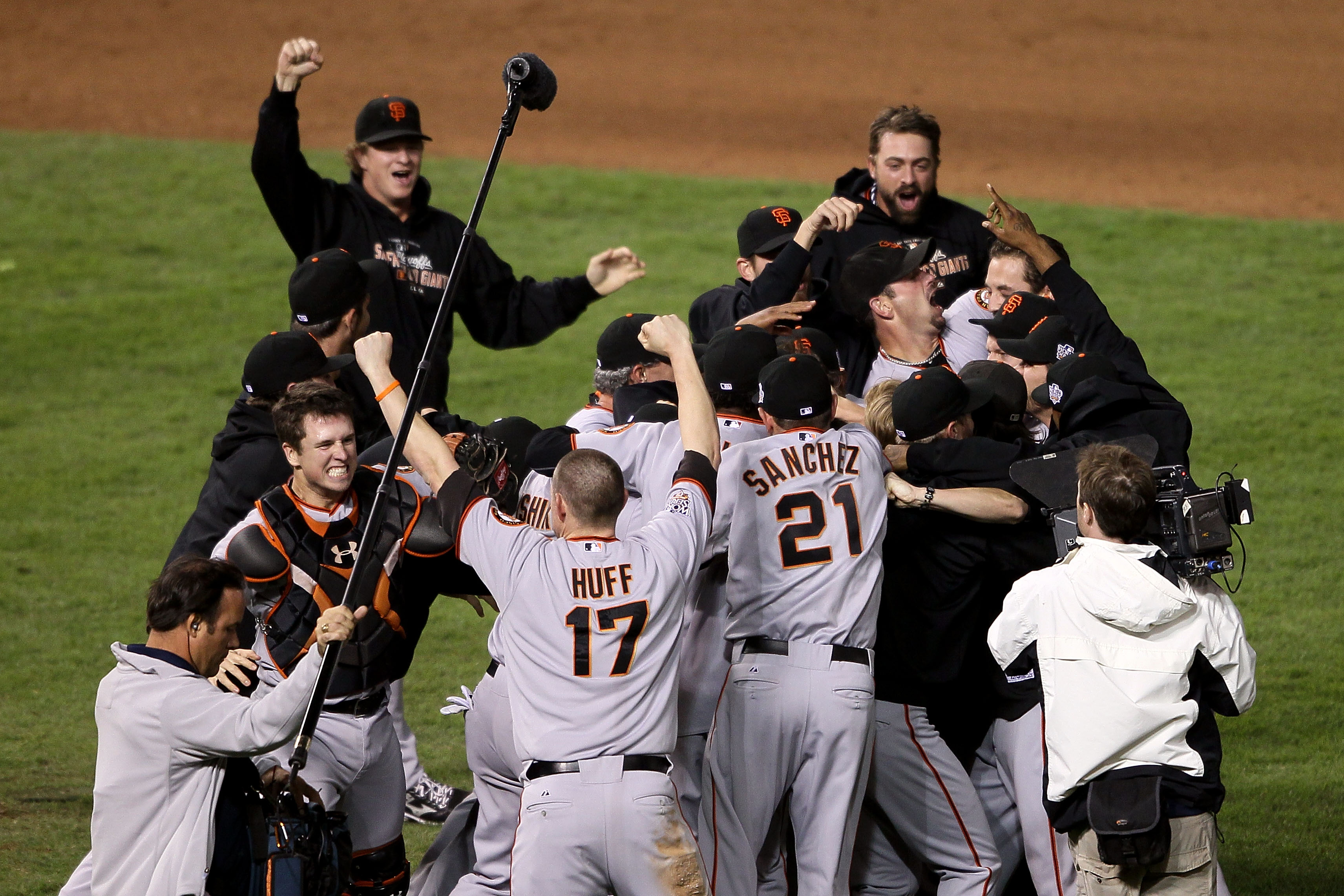 ARLINGTON, TX - NOVEMBER 01:  Catcher Buster Posey #28, Aubrey Huff #17, Freddy Sanchez #21 and Matt Cain #18 (top L) of the San Francisco Giants celebrate on the field with their teammates after the Giants won 3-1 against the Texas Rangers in Game Five o