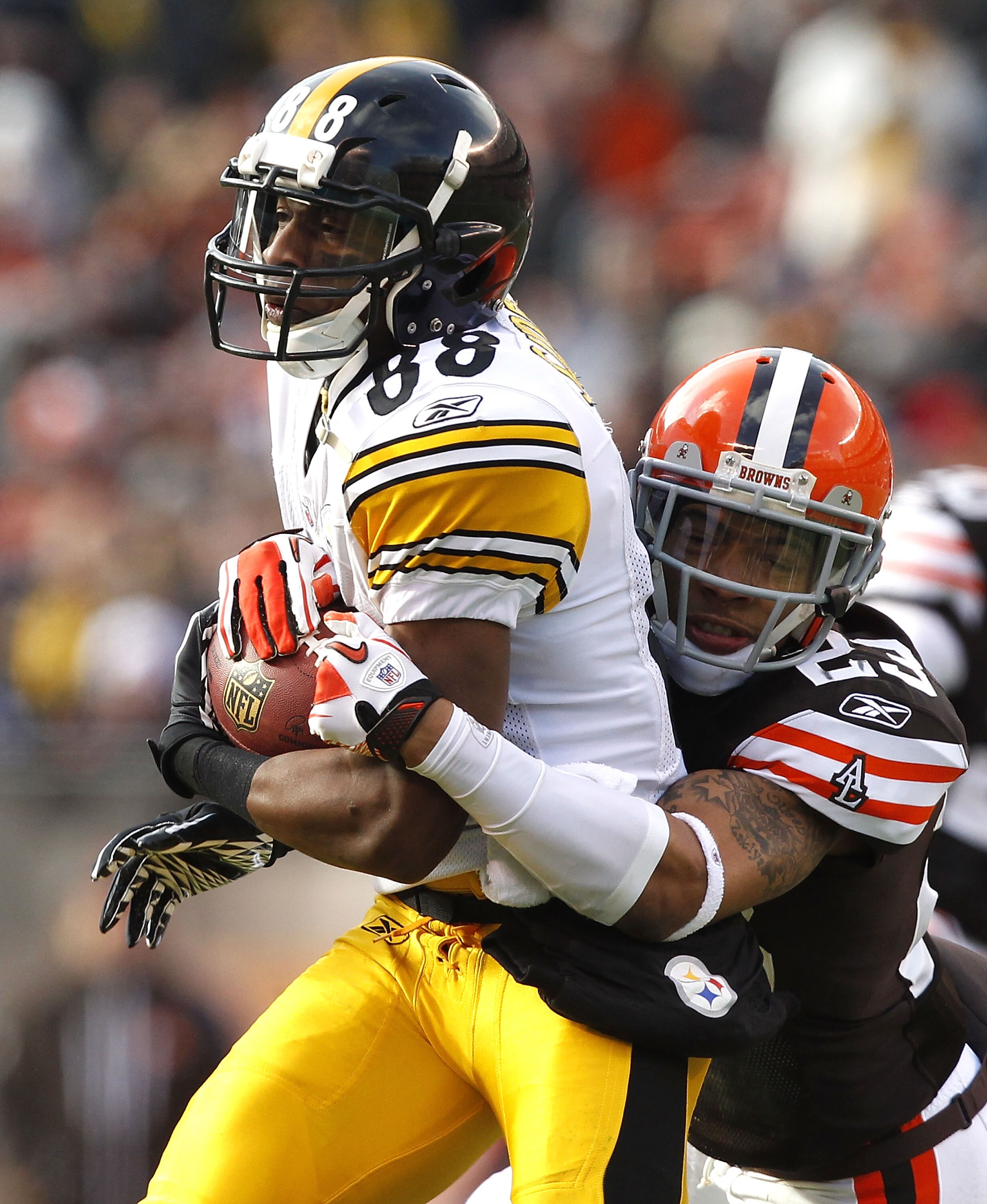 CLEVELAND, OH - JANUARY 02:  Wide receiver Emmanuel Sanders #88 of the Pittsburgh Steelers runs the ball as he is hit by defensive back Joe Haden #23 of the Cleveland Browns at Cleveland Browns Stadium on January 2, 2011 in Cleveland, Ohio.  (Photo by Mat