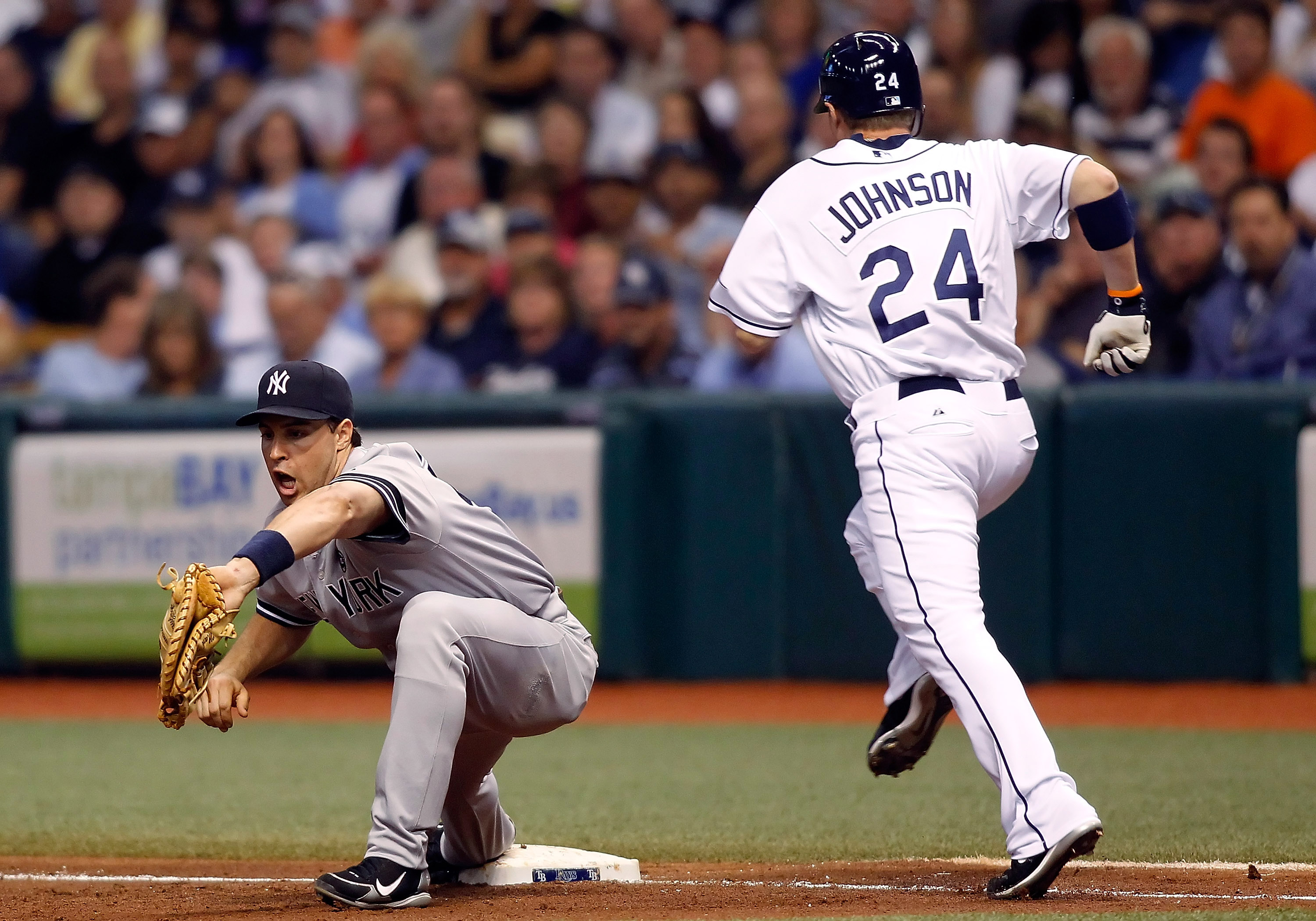 ST. PETERSBURG, FL - SEPTEMBER 15:  First baseman Mark Teixeira #25 of the New York Yankees takes the throw at first for an out as Dan Johnson #24 of the Tampa Bay Rays cannot beat the throw during the game at Tropicana Field on September 15, 2010 in St. 