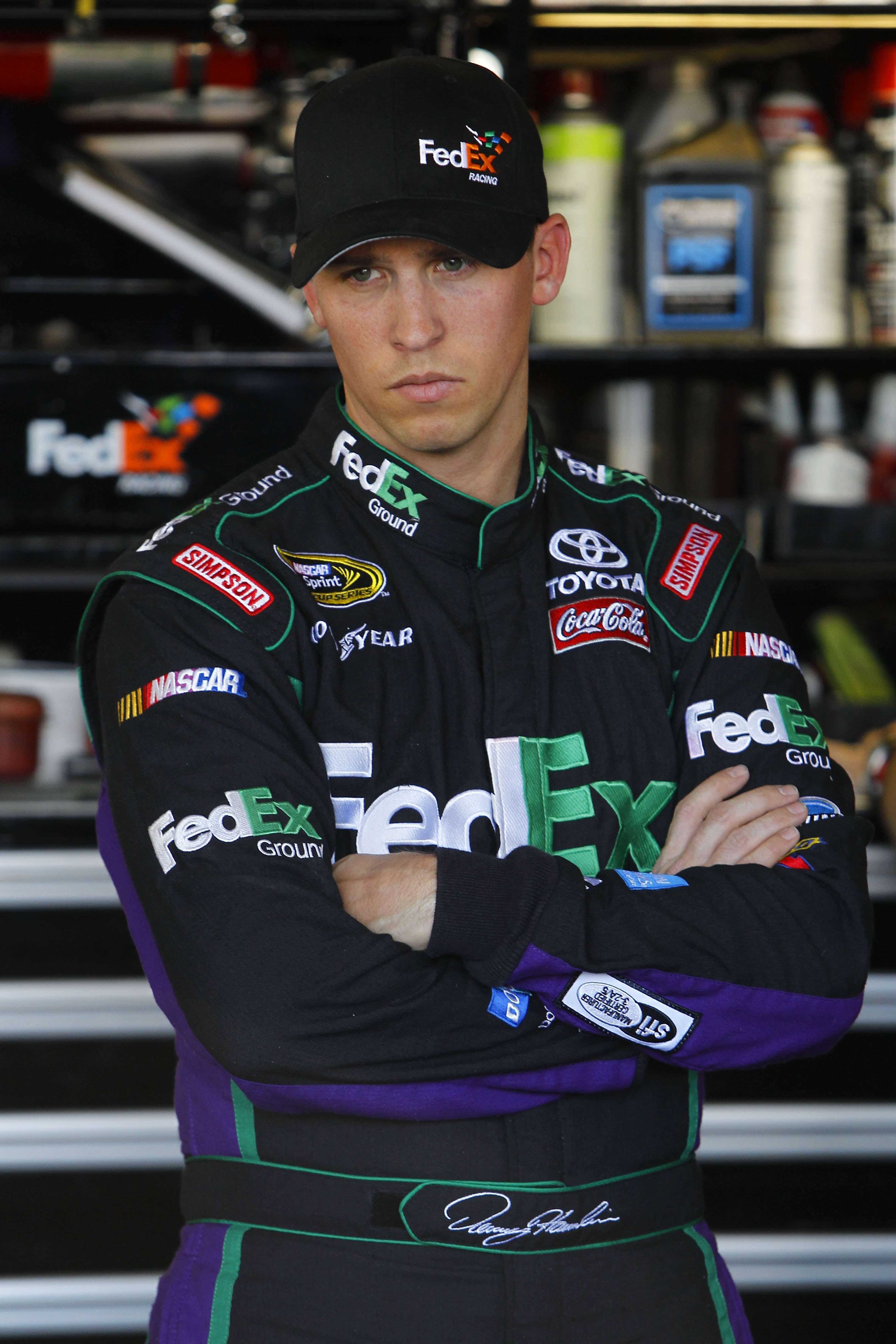 AVONDALE, AZ - NOVEMBER 12:  Denny Hamlin, driver of the #11 FedEx Toyota, stands in the garage during practice for the NASCAR Sprint Cup Series Kobalt Tools 500 at Phoenix International Raceway on November 12, 2010 in Avondale, Arizona.  (Photo by Chris