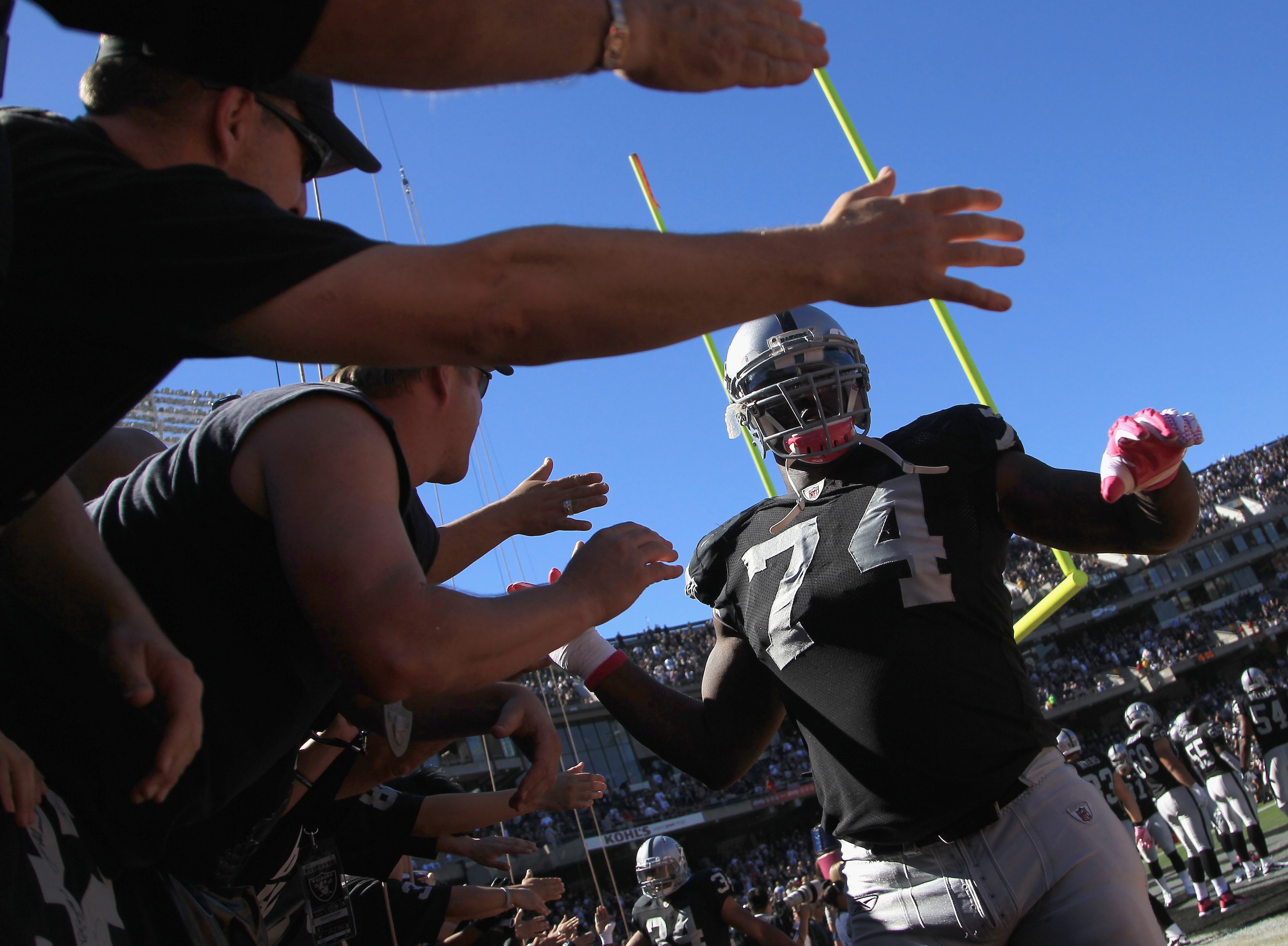 OAKLAND, CA - OCTOBER 10:  Bruce Campbell #74 of the Oakland Raiders high fives fans before their game against the San Diego Chargers at Oakland-Alameda County Coliseum on October 10, 2010 in Oakland, California.  (Photo by Ezra Shaw/Getty Images)
