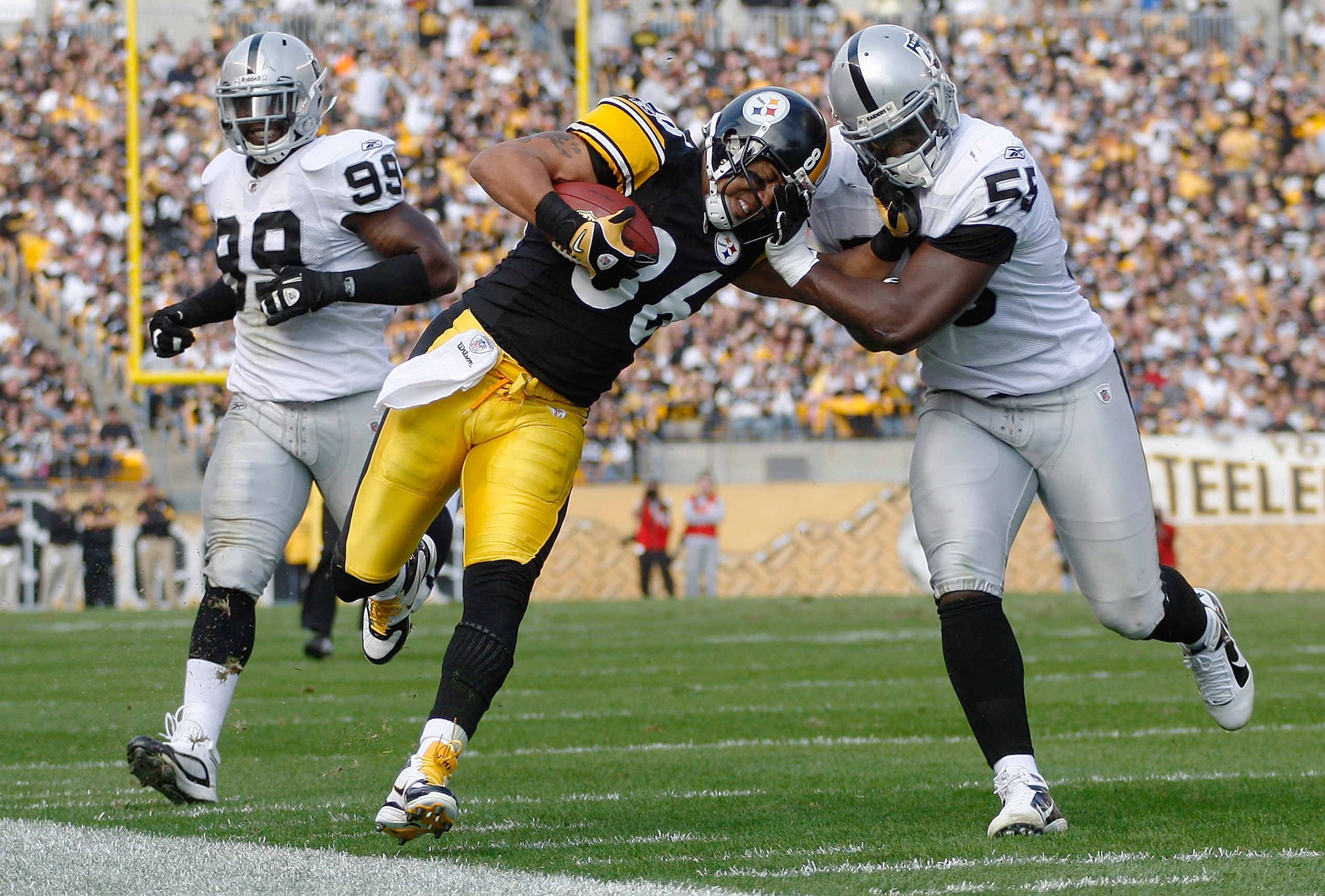 PITTSBURGH - NOVEMBER 21:  Hines Ward #86 of the Pittsburgh Steelers attempts to stiff arm Rolando McClain #55 of the Oakland Raiders after a catch during the game on November 21, 2010 at Heinz Field in Pittsburgh, Pennsylvania.  (Photo by Jared Wickerham