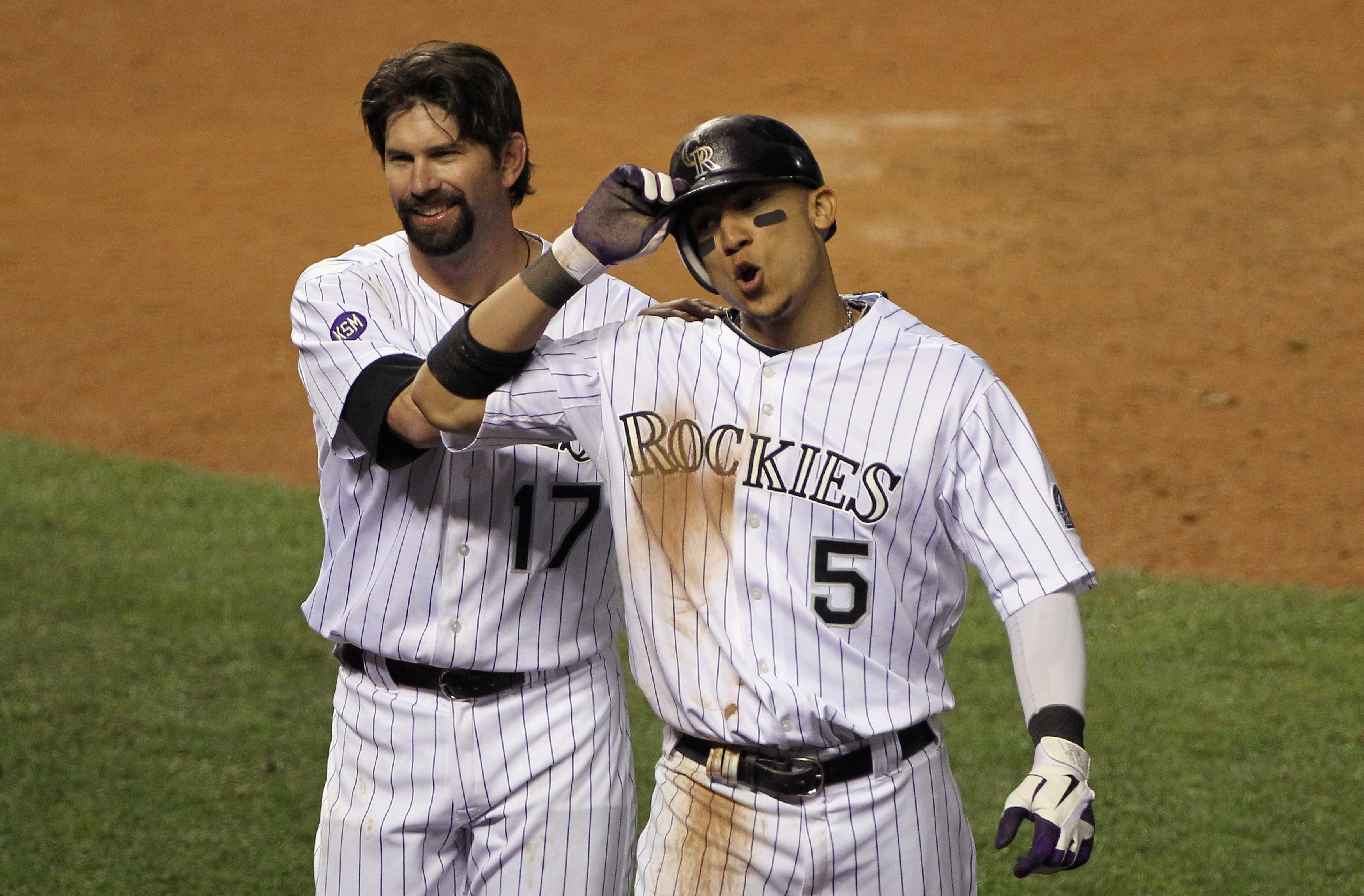 DENVER - SEPTEMBER 25:  Carlos Gonzalez #5 of the Colorado Rockies breathes deep as he celebrates with Todd Helton #17 after Gonzalez scored the game winning against the San Francisco Giants on a double by Troy Tulowitzki in the 10th inning at Coors Field
