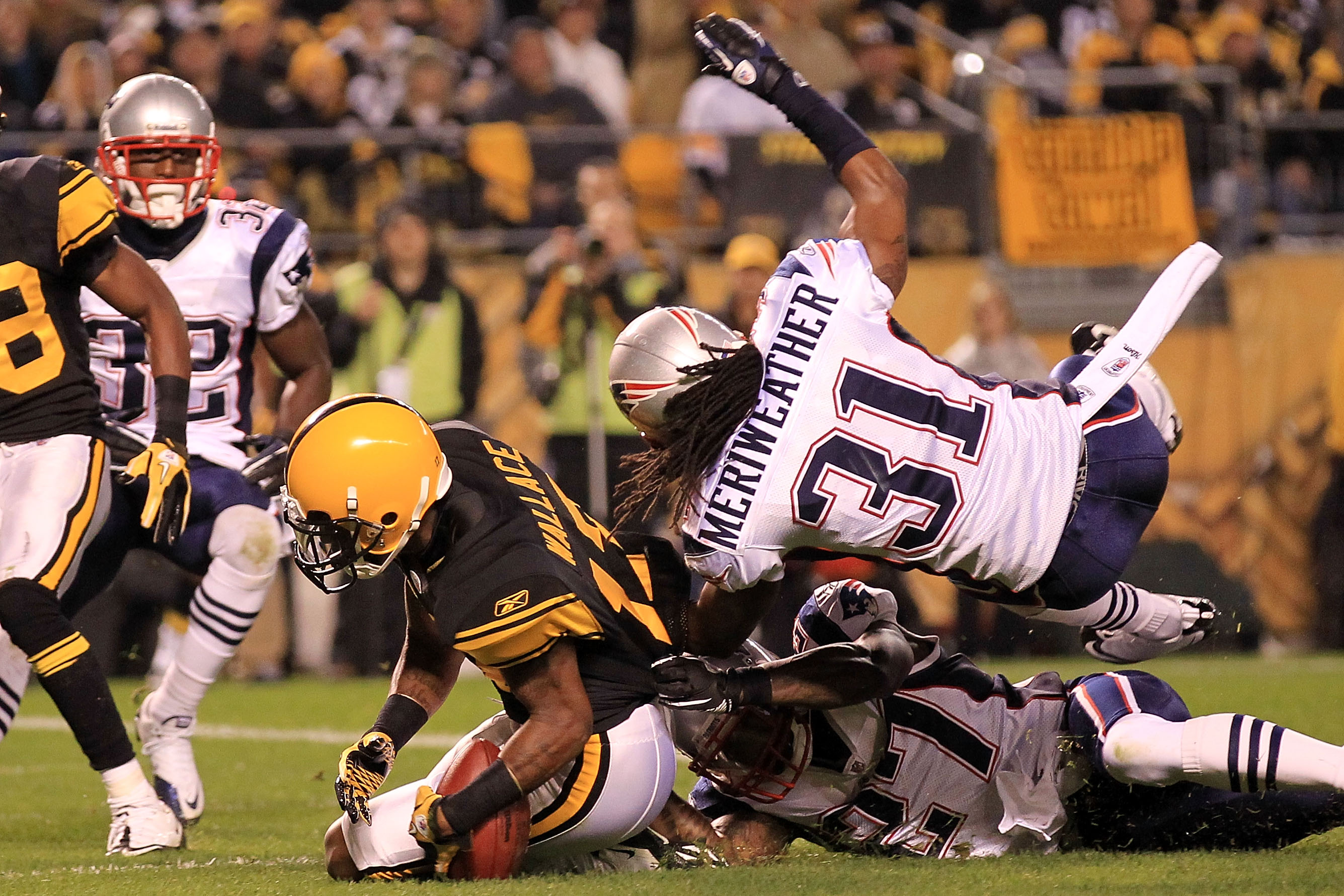 PITTSBURGH - NOVEMBER 14: Mike Wallace #17 of the Pittsburgh Steelers drops the ball in the endzone under pressure from Brandon Meriweather #31 and Kyle Arrington #27 of the New England Patriots on November 14, 2010 at Heinz Field in Pittsburgh, Pennsylv