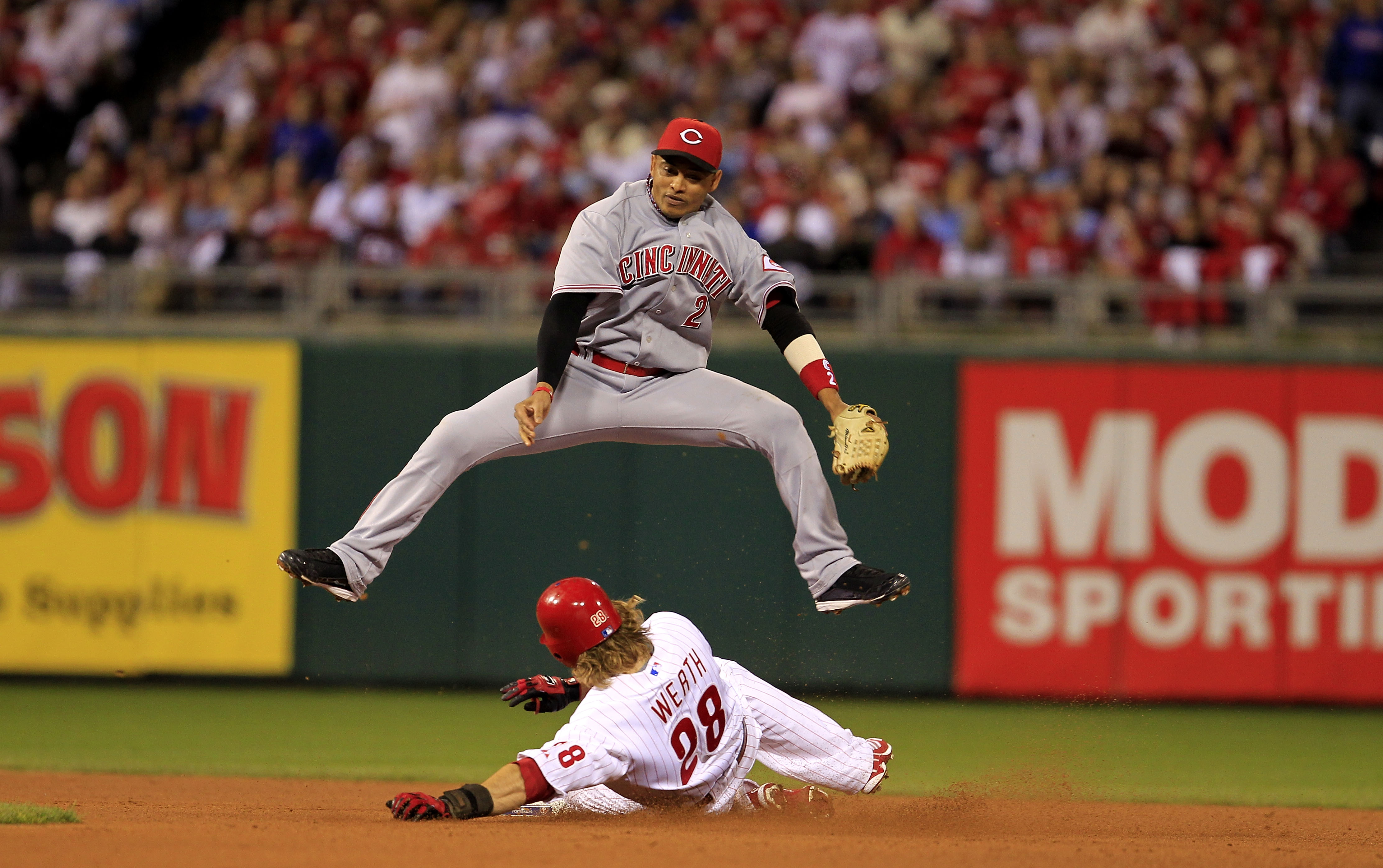 PHILADELPHIA - OCTOBER 08:  Orlando Cabrera #2 of the Cincinnati Reds leaps over Jayson Werth #28 of the Philadelphia Phillies as Werth steals second base during game 2 of the NLDS at Citizens Bank Park on October 8, 2010 in Philadelphia, Pennsylvania. Th
