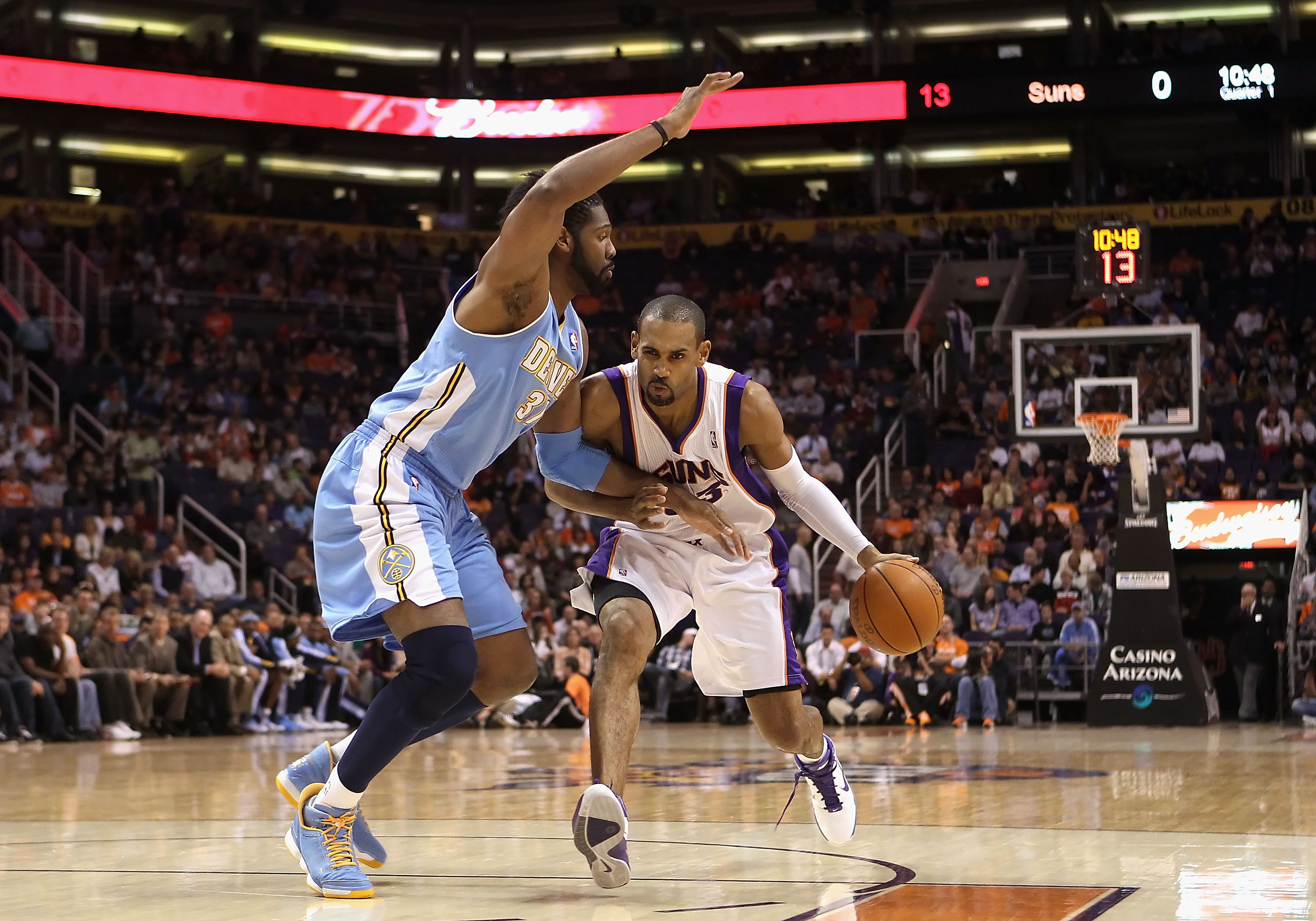 PHOENIX - NOVEMBER 15:  Grant Hill #33 of the Phoenix Suns hanldes the ball under pressure from Nene #31 of the Denver Nuggets during the NBA game at US Airways Center on November 15, 2010 in Phoenix, Arizona. NOTE TO USER: User expressly acknowledges and