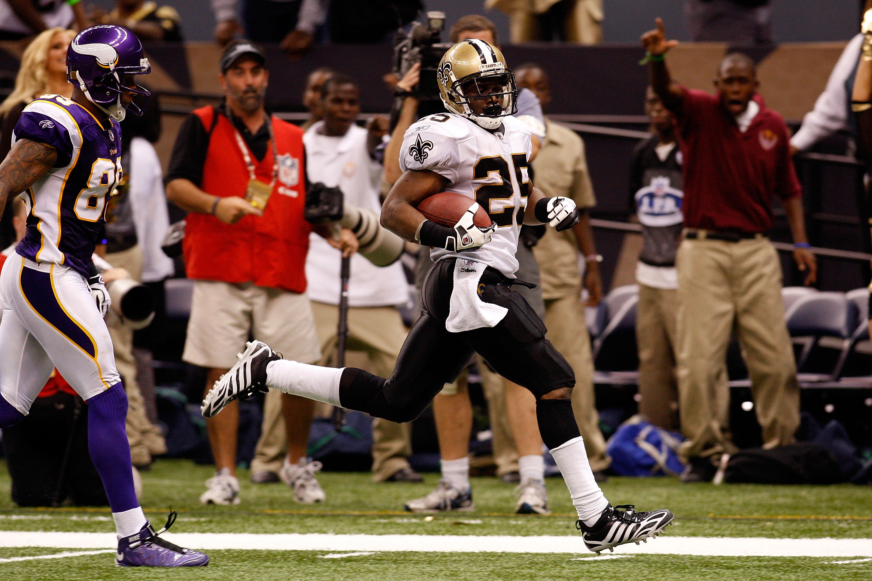 New Orleans Saints' running Back Reggie Bush (R) runs away from