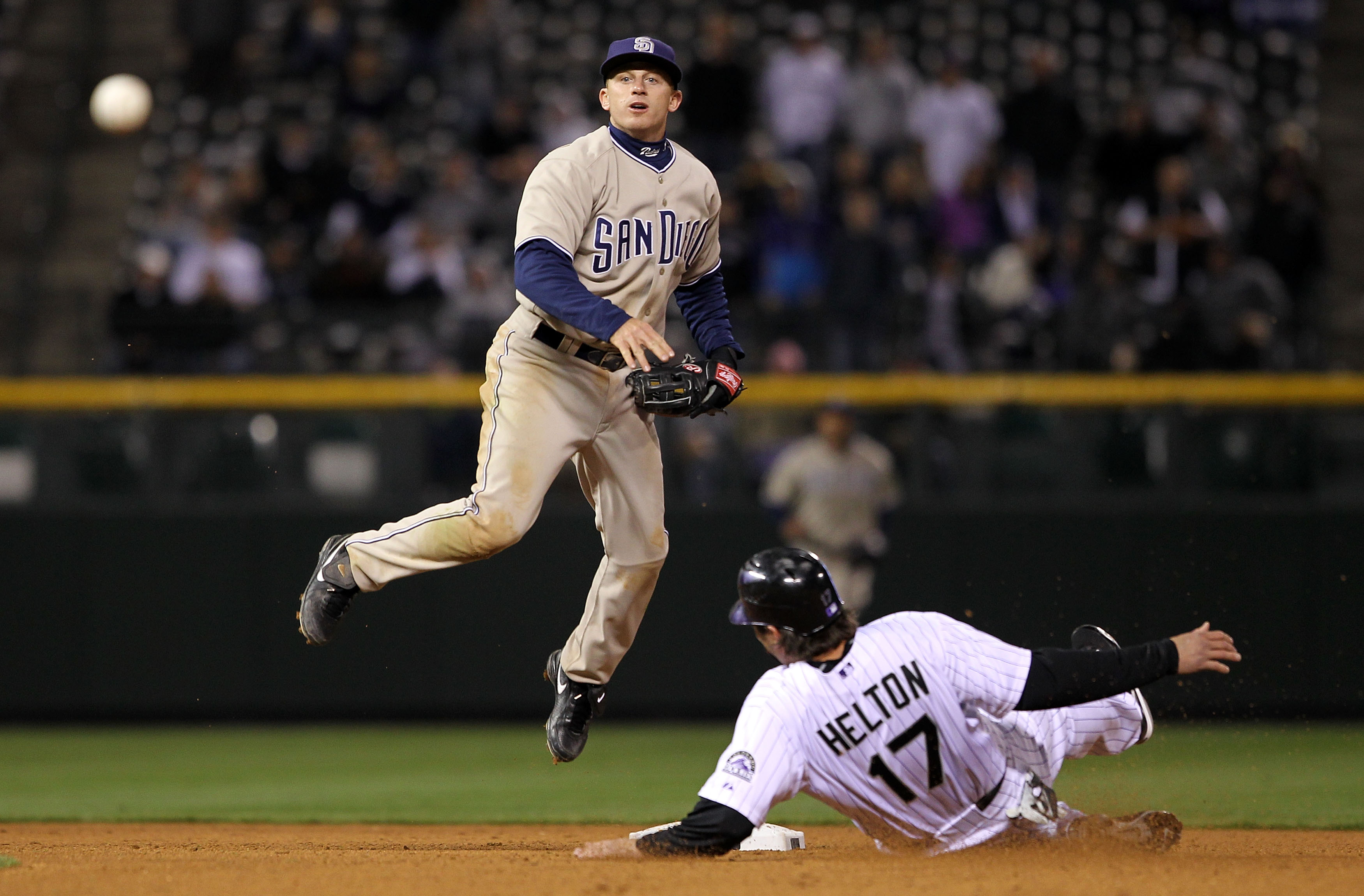 DENVER - APRIL 10:  Second baseman David Eckstein #22 of the San Diego Padres turns a double play on Todd Helton #17 of the Colorado Rockies on a grounder by Troy Tulowitzki to Chase Headley in the 14th inning during MLB action at Coors Field on April 10,