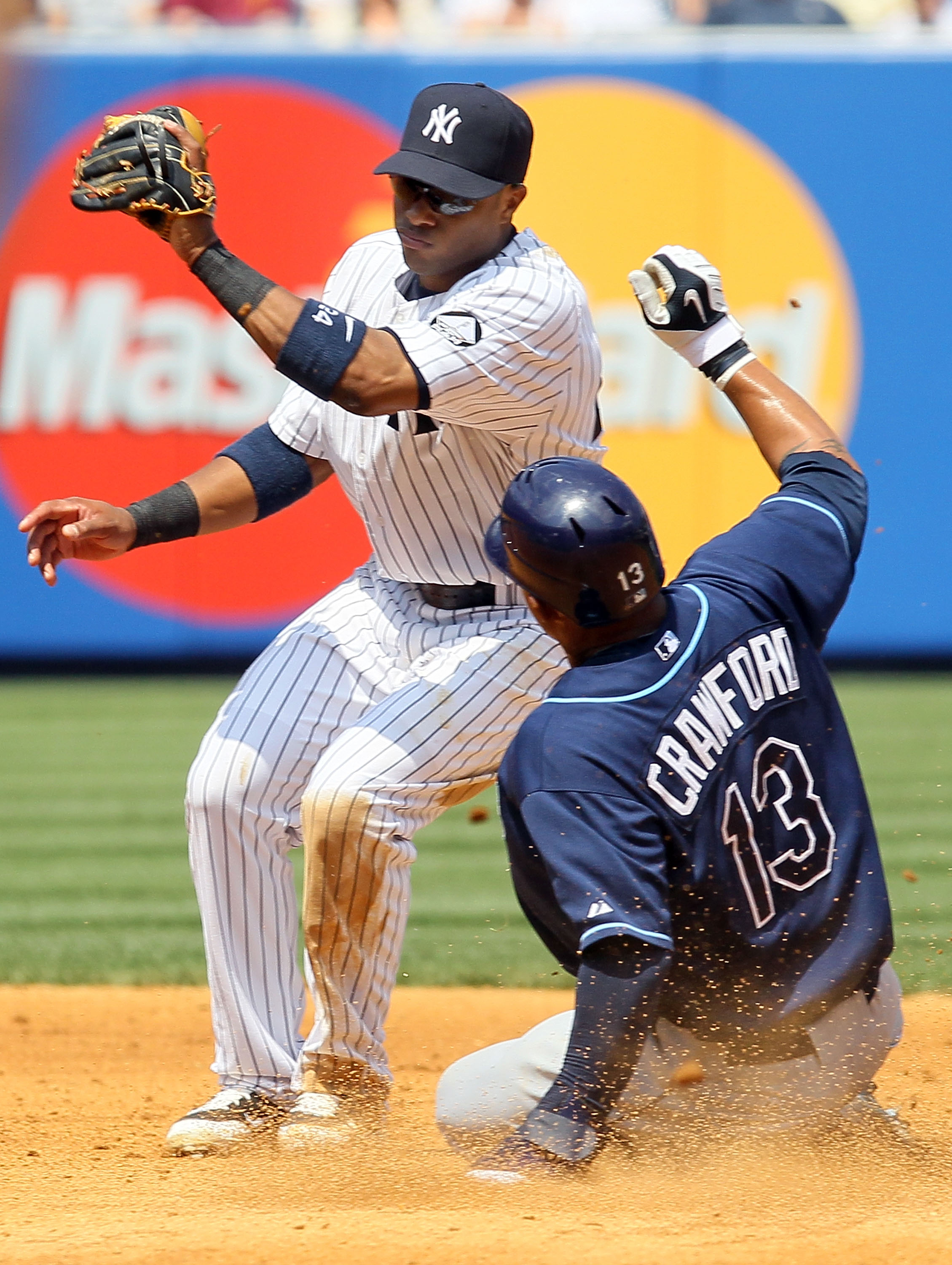 NEW YORK - JULY 18:  Robinson Cano #24 of the New York Yankees is late with the tag as Carl Crawford #13 of the Tampa Bay Rays steals second base on July 18, 2010 at Yankee Stadium in the Bronx borough of New York City.  (Photo by Jim McIsaac/Getty Images
