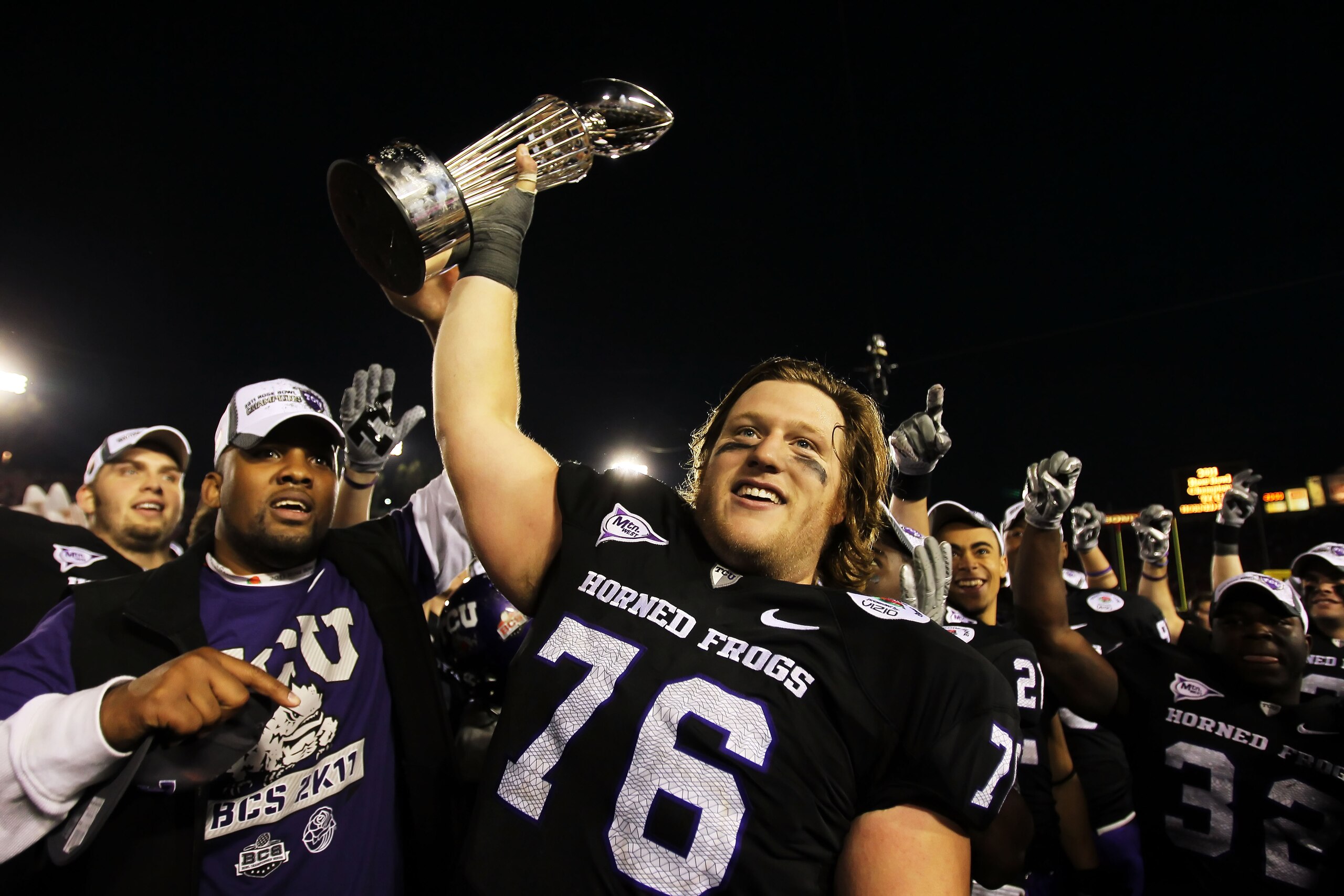 PASADENA, CA - JANUARY 01:  Center Jake Kirkpatrick #76 of the TCU Horned Frogs celebrates with the Rose Bowl Championship Trophy after defeating the Wisconsin Badgers 21-19 in the 97th Rose Bowl game on January 1, 2011 in Pasadena, California.  (Photo by