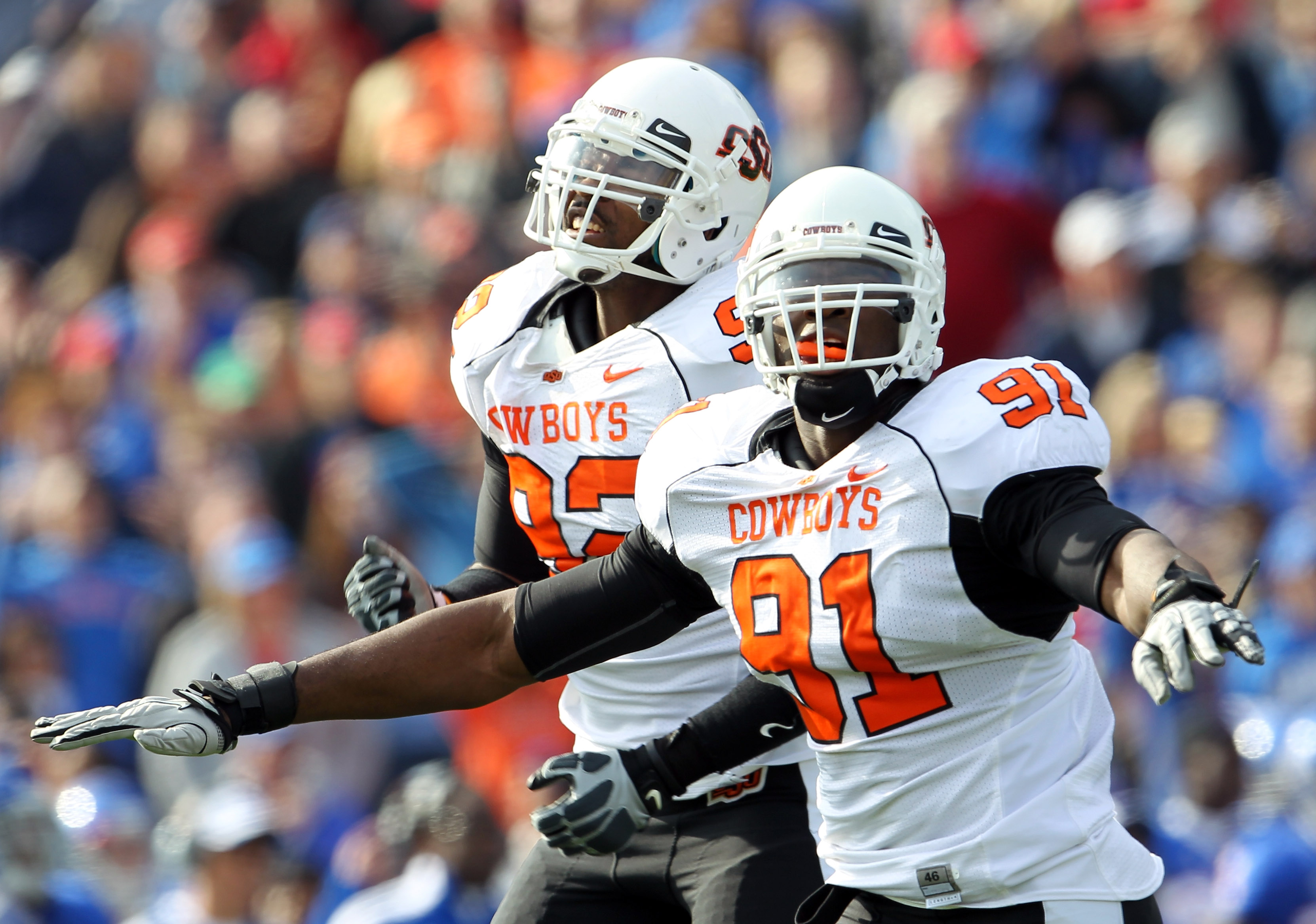 LAWRENCE, KS - NOVEMBER 20:  Ugo Chinasa #91 and Darius Hart #92 of the Oklahoma State Cowboys celebrate after the Cowboys stopped the Kansas Jayhawks from scoring at the goal line during the game on November 20, 2010 at Memorial Stadium in Lawrence, Kans