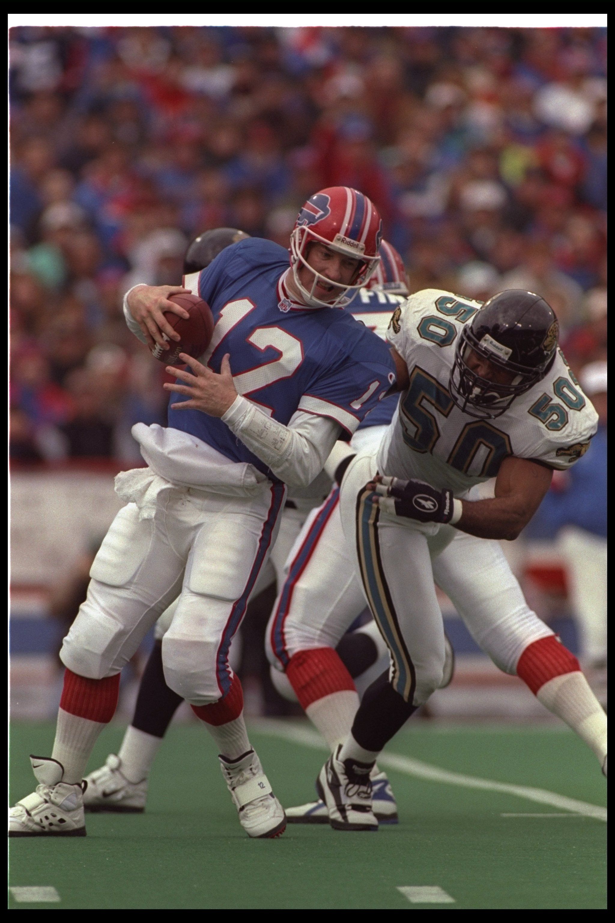 28 Dec 1996:  Linebacker Eddie Robinson of the Jacksonville Jaguars tackles Buffalo Bills quarterback Jim Kelly during a playoff game at Rich Stadium in Orchard Park, New York.  The Jaguars won the game, 30-27. Mandatory Credit: Rick Stewart  /Allsport