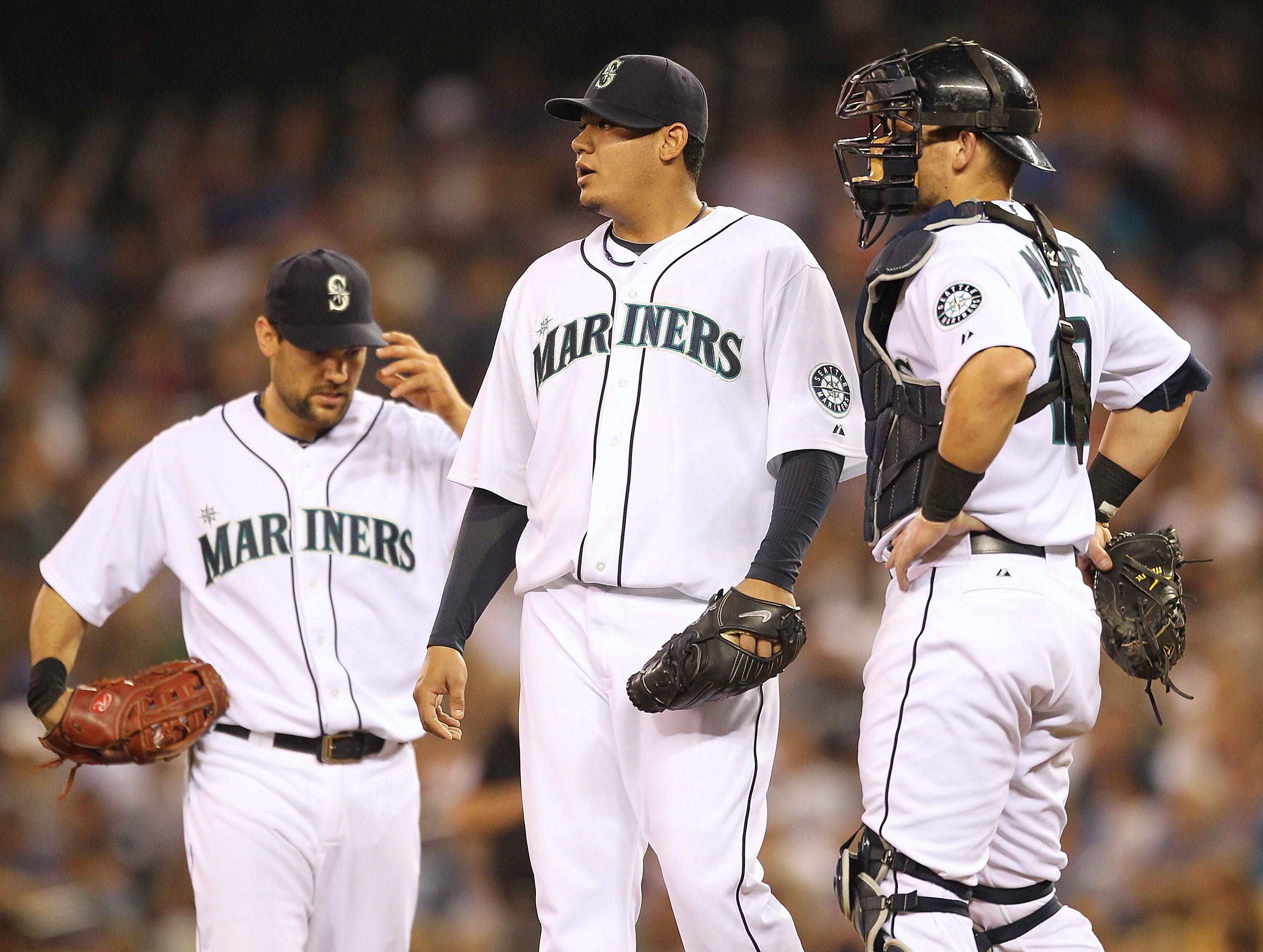 SEATTLE - AUGUST 05:  Starting pitcher Felix Hernandez #34 of the Seattle Mariners pauses just before being removed from the game as first baseman Casey Kotchman #13 and catcher Adam Moore #10 look on in the seventh inning against the Texas Rangers at Saf
