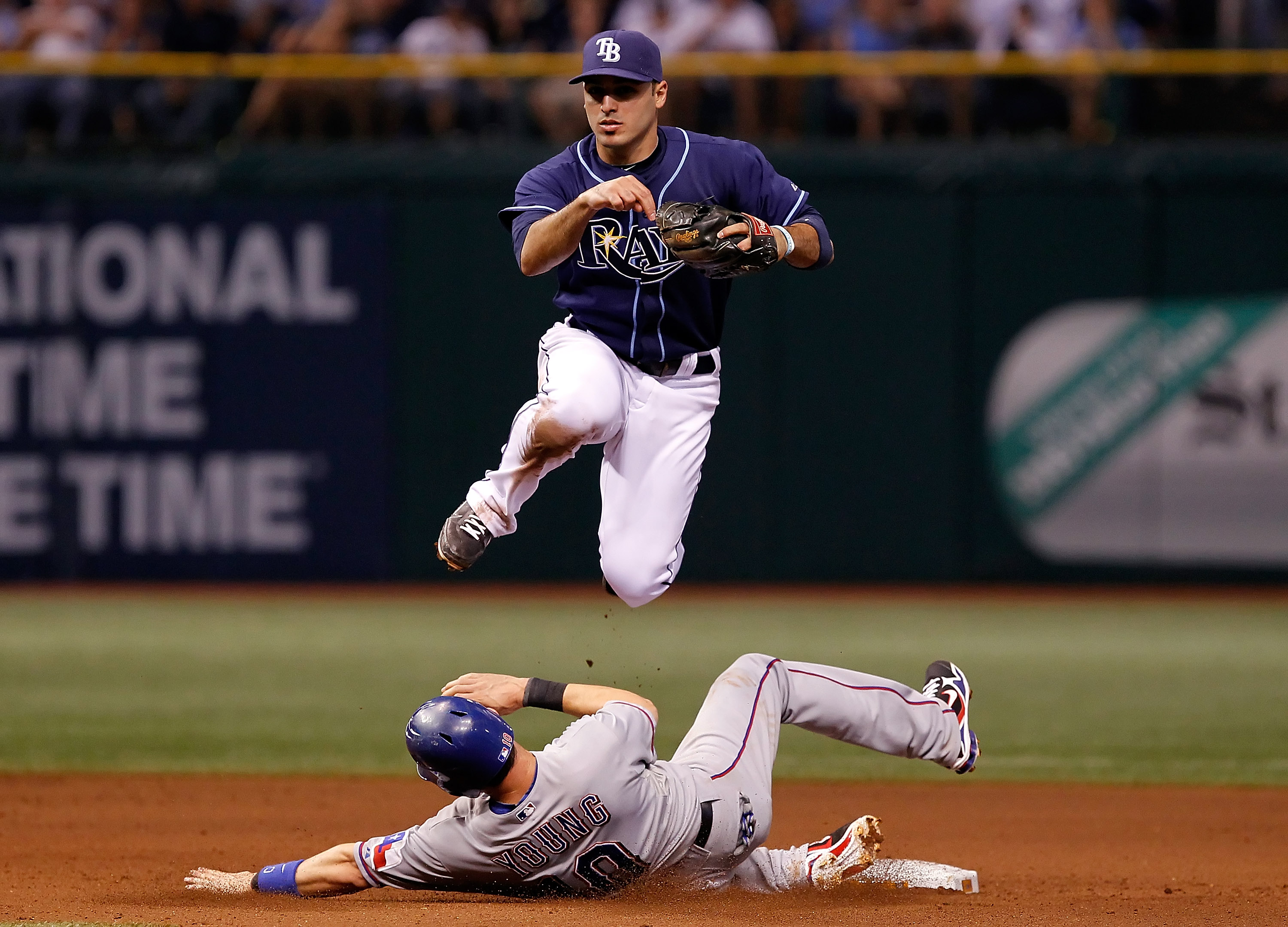 ST. PETERSBURG, FL - OCTOBER 12:  Infielder Sean Rodriguez #1 of the Tampa Bay Rays turns a double play as Michael Young #10 of the Texas Rangers tries to break it up during Game 5 of the ALDS at Tropicana Field on October 12, 2010 in St. Petersburg, Flor