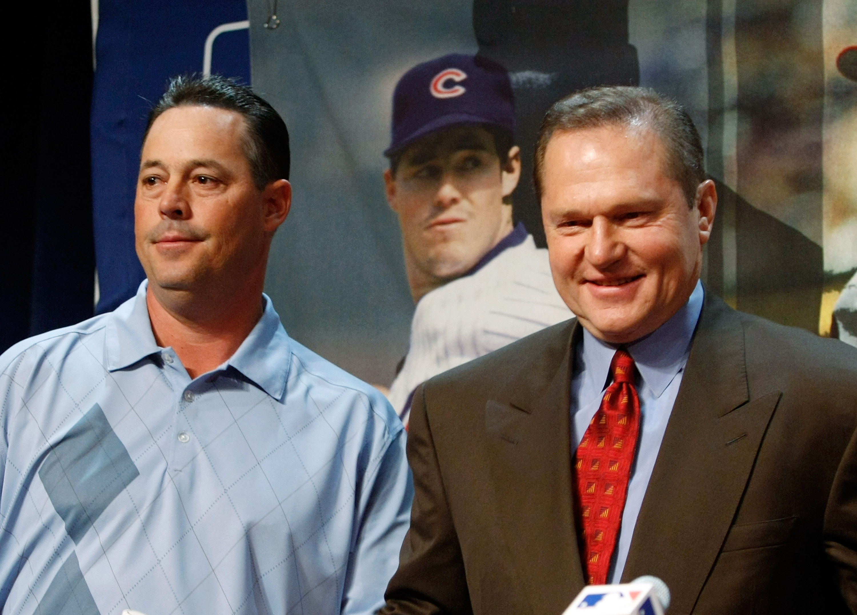 Chicago Cubs general manager Jim Hendry (R) puts a jersey on