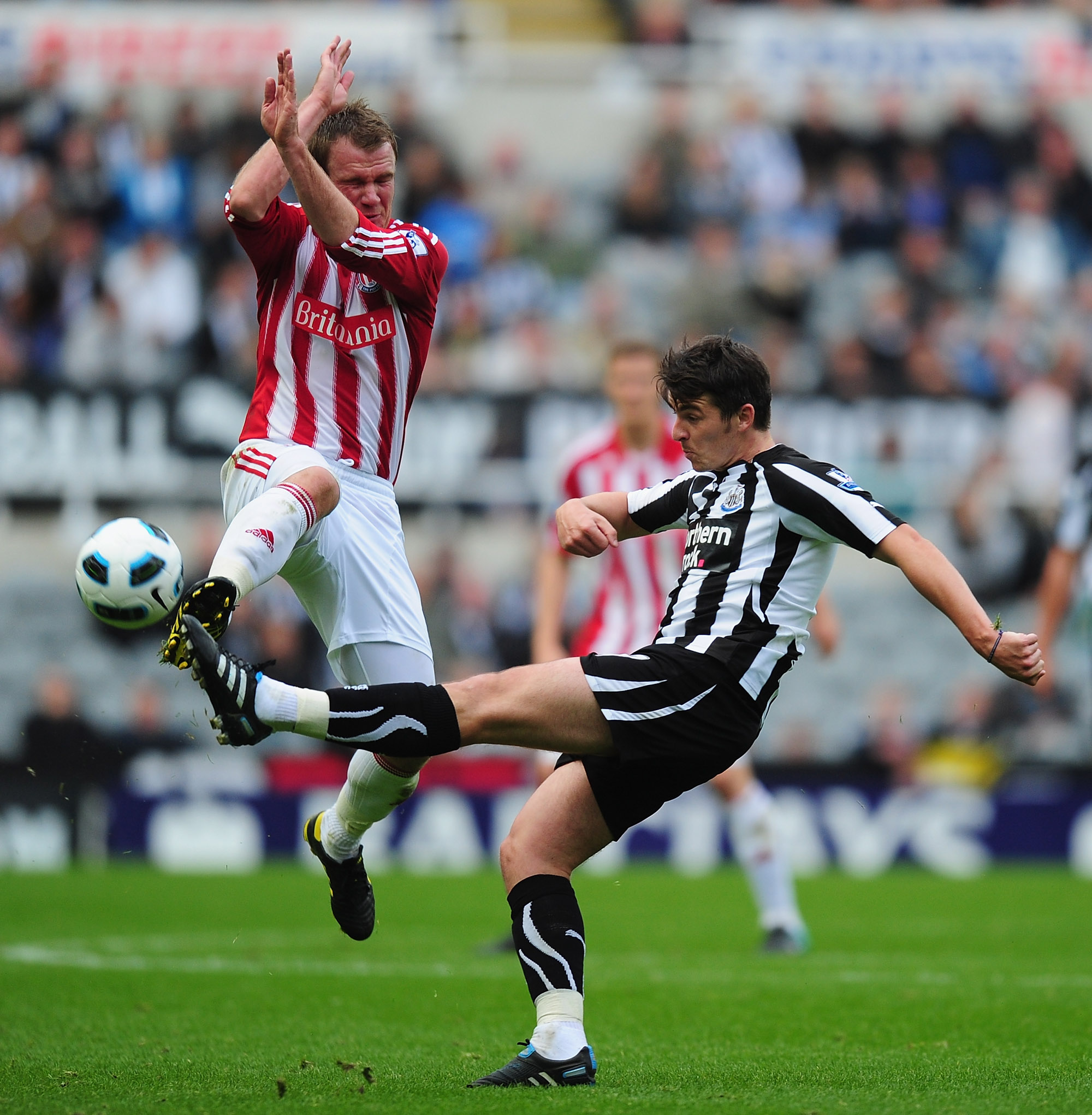 NEWCASTLE UPON TYNE, ENGLAND - SEPTEMBER 26:  Joey Barton of Newcastle United is challenged by Glen Whelan of Stoke City during the Barclays Premier League match between Newcastle United and Stoke City at St James' Park on September 26, 2010 in Newcastle 