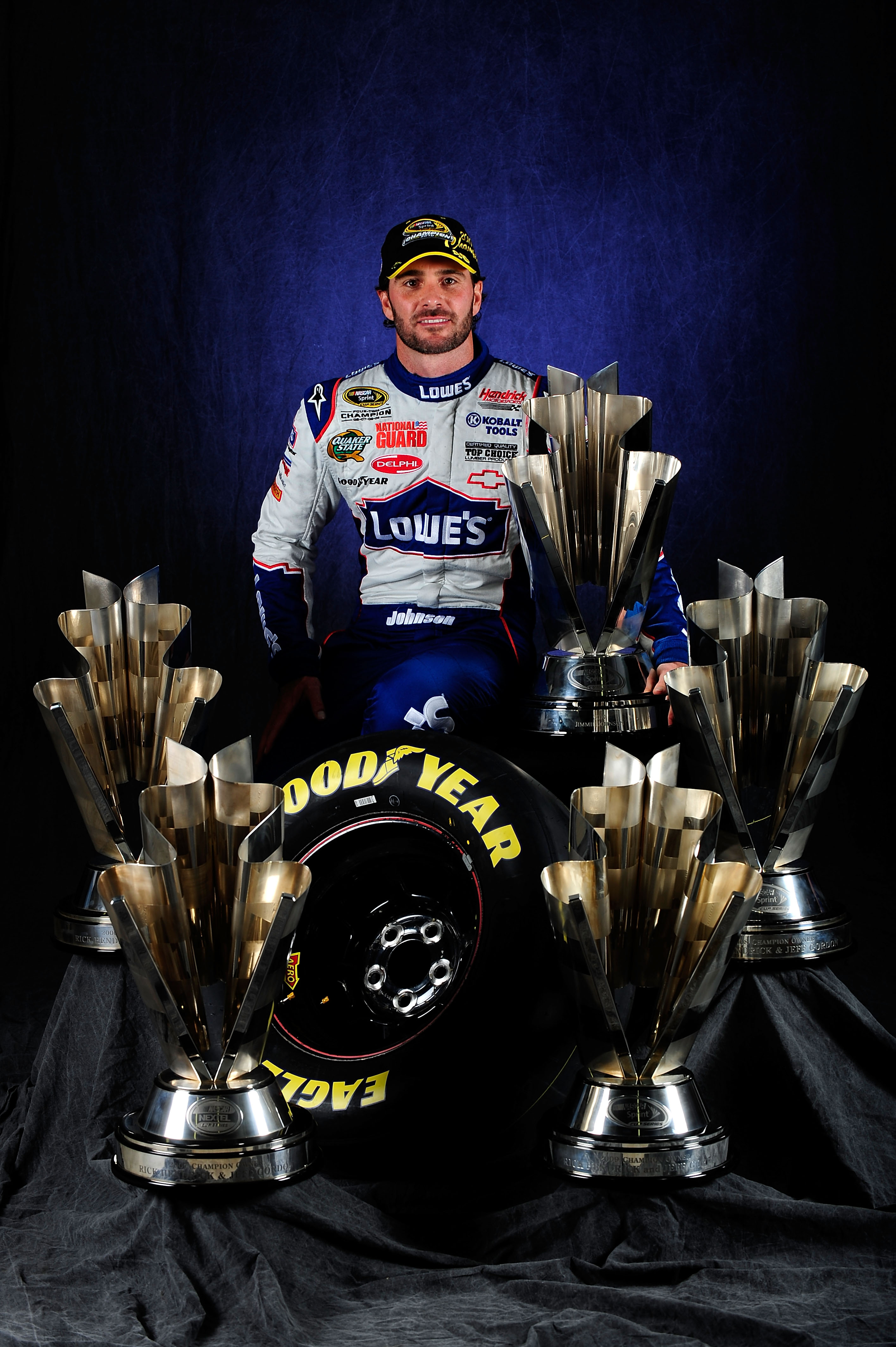 HOMESTEAD, FL - NOVEMBER 21:  NASCAR Champion Jimmie Johnson, driver of the #48 Lowe's Chevrolet, poses with the Sprint Cup Series Championship trophies at Homestead-Miami Speedway on November 21, 2010 in Homestead, Florida. Johnson clinched his fifth str
