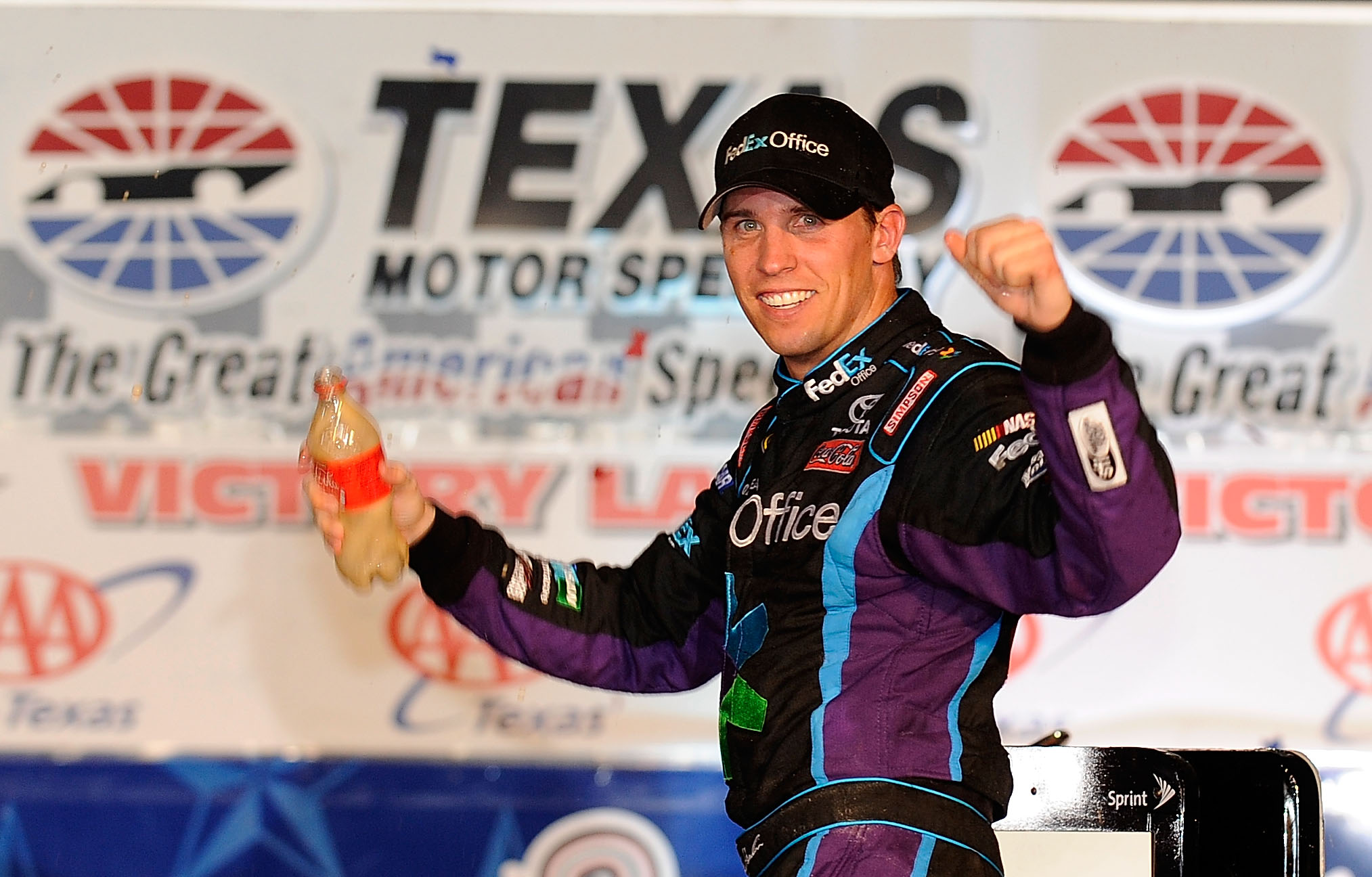 FORT WORTH, TX - NOVEMBER 07:  Denny Hamlin, driver of the #11 FedEx Office Toyota, celebrates in Victory Lane after winning the NASCAR Sprint Cup Series AAA Texas 500 at Texas Motor Speedway on November 7, 2010 in Fort Worth, Texas.  (Photo by Rusty Jarr