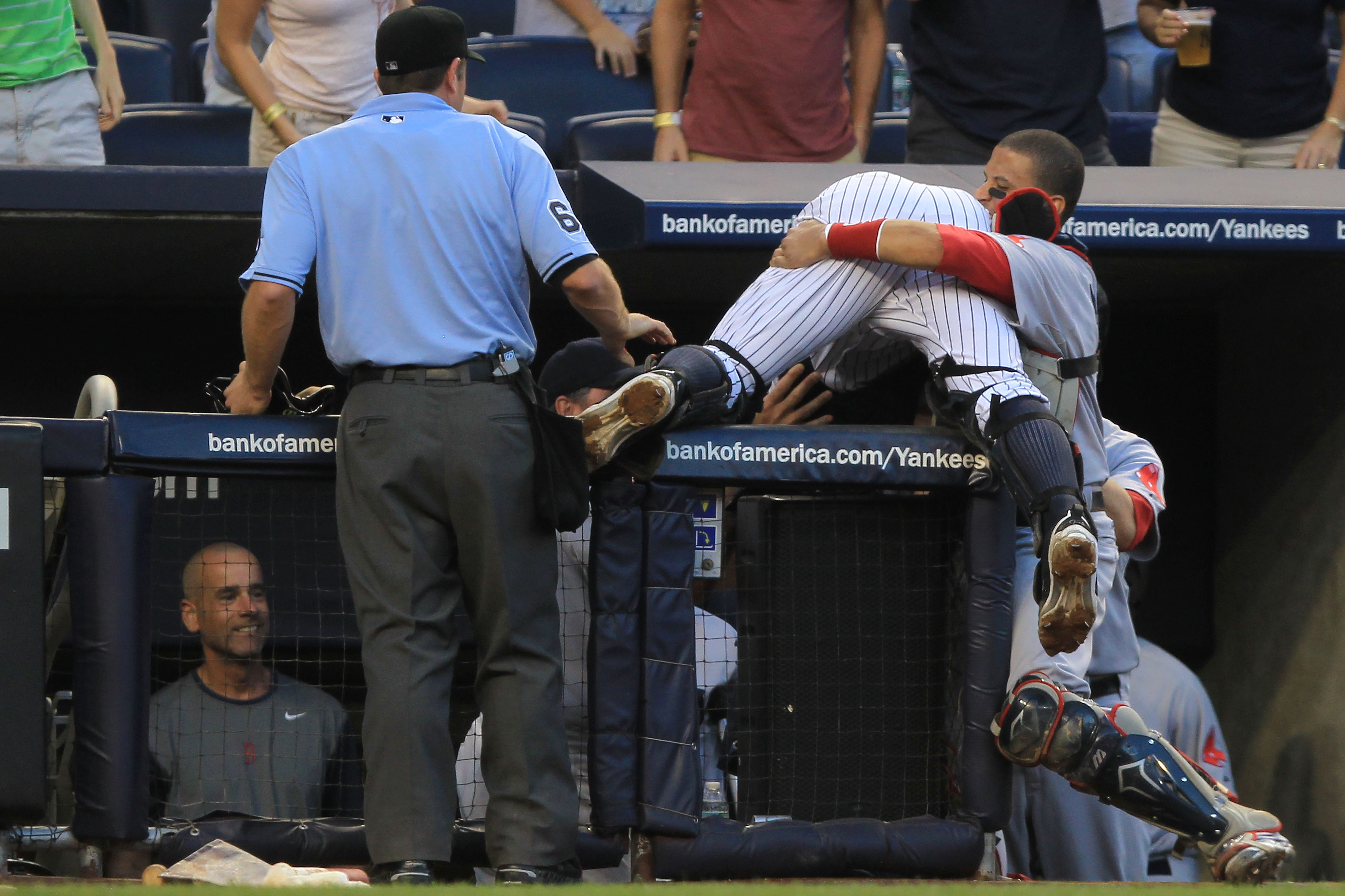 NEW YORK - SEPTEMBER 25:  Francisco Cervelli #29 of the New York Yankees is helped by Victor Martinez #41 of the Boston Red Sox after falling over the Red Sox dugout wall trying to catch a foul ball during their game on September 25, 2010 at Yankee Stadiu
