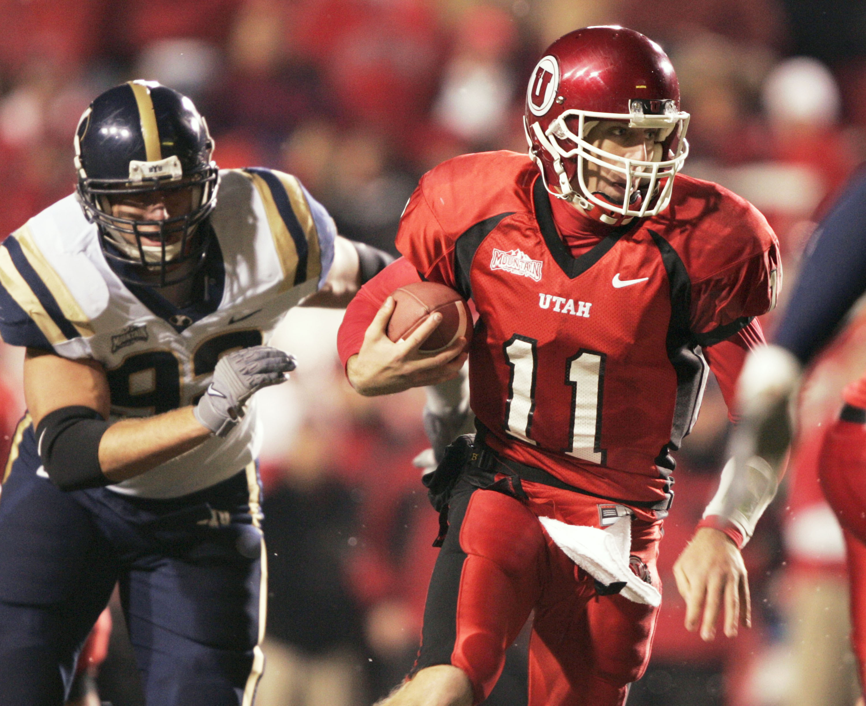 SALT LAKE CITY, UT - NOVEMBER 20: Quarterback Alex Smith #11 of the University of Utah scrambles for a first down as John Denney #92 of BYU gives chase during the second quarter November 20, 2004 at Rice Eccles Stadium in Salt Lake City, Utah. (Photo by G