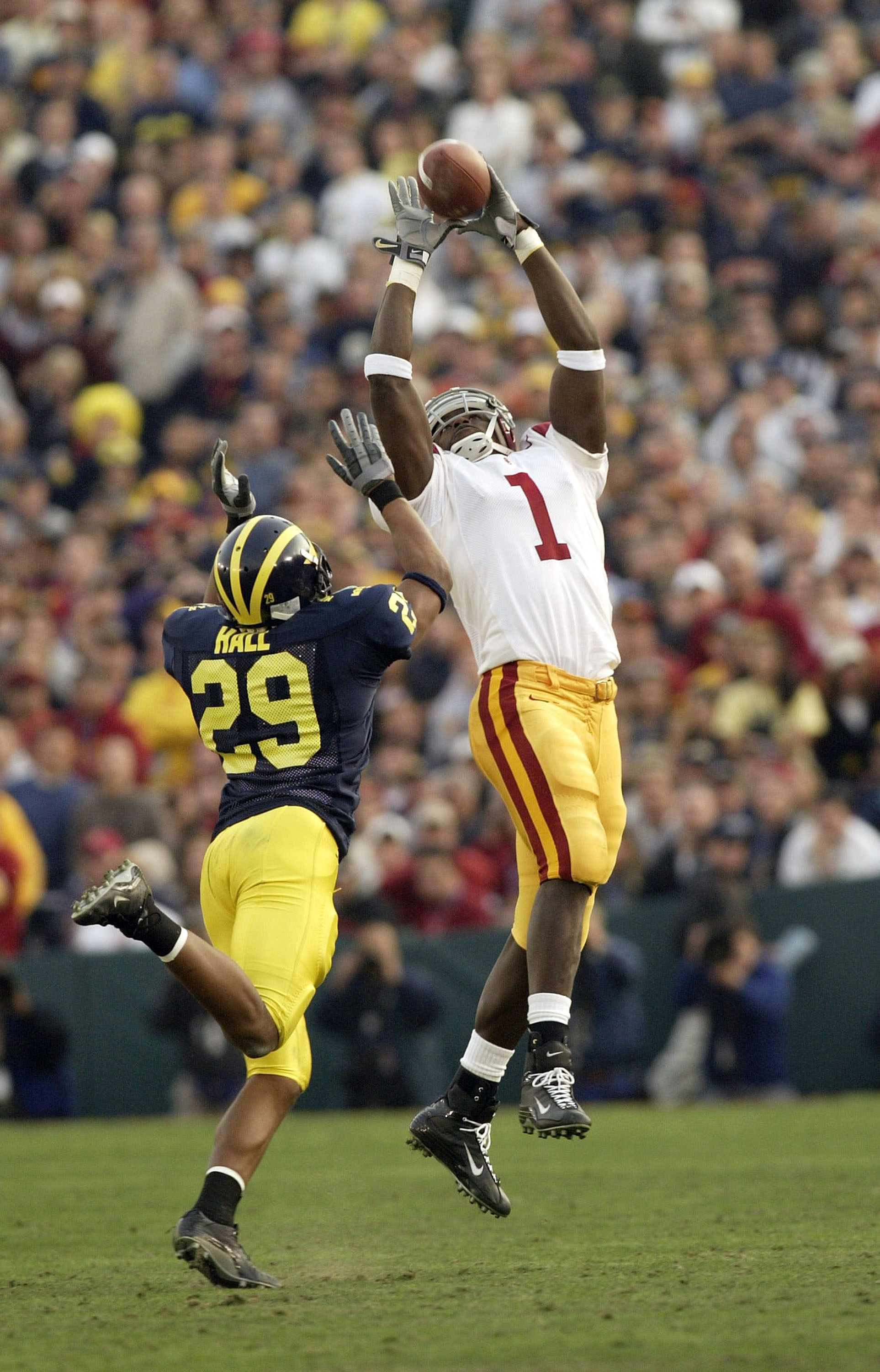 PASADENA, CA - JANUARY 1:  Wide receiver Mike Williams #1 of the USC Trojans makes a catch in front of cornerback Leon Hall of the Michigan Wolverines in the 2004 Rose Bowl on January 1, 2004 at the Rose Bowl in Pasadena, California. USC defeated Michigan
