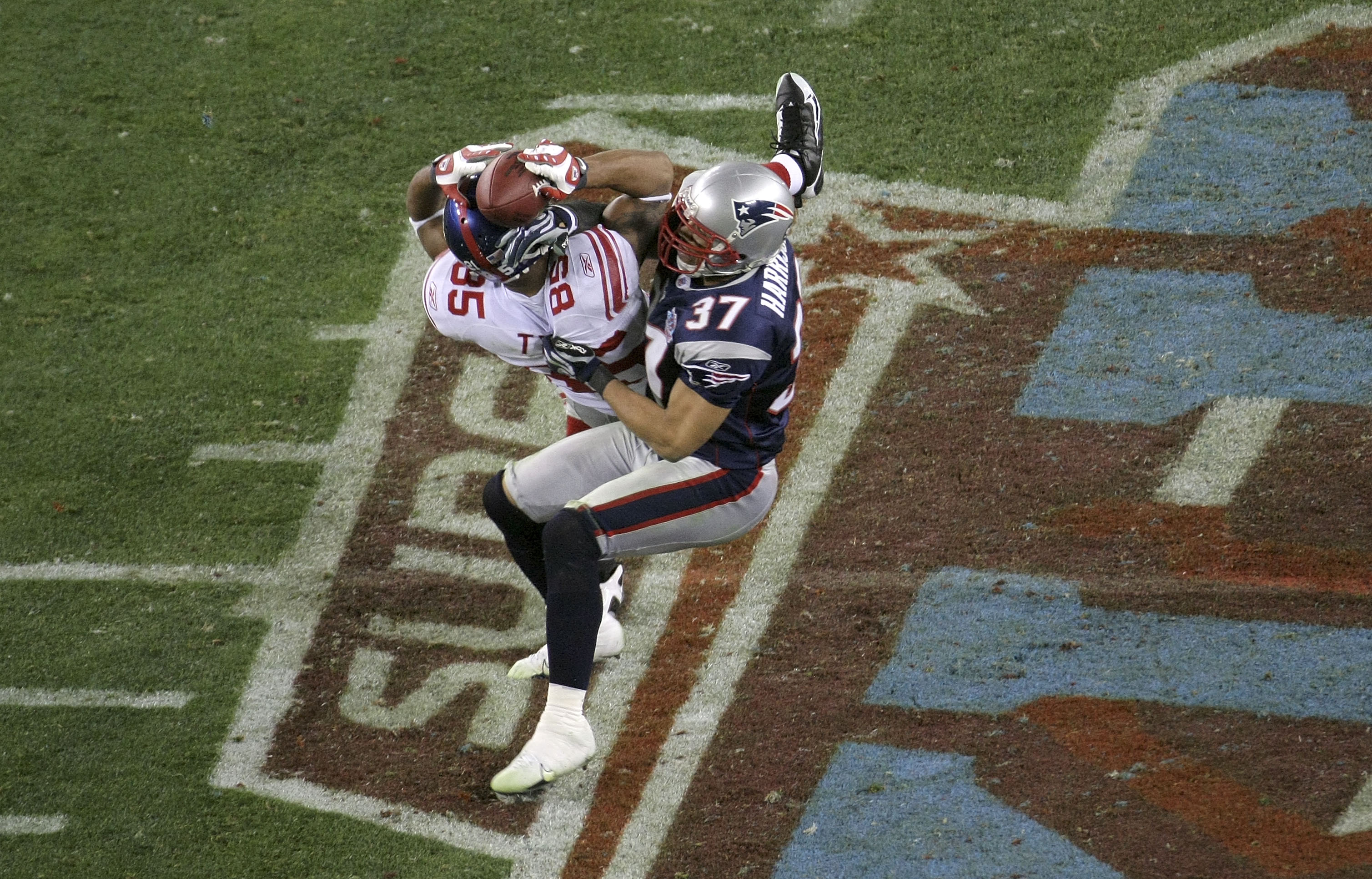 GLENDALE, AZ - FEBRUARY 03:  David Tyree #85 of the New York Giants catches a 32-yard pass from Eli Manning #10 as Rodney Harrison #37 of the New England Patriots attempts to knock it out in the fourth quarter of Super Bowl XLII on February 3, 2008 at the