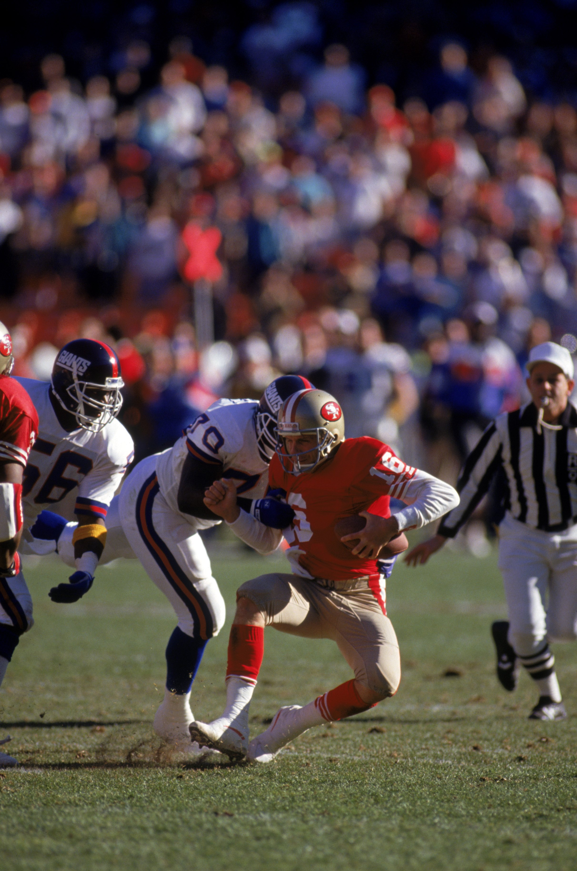 SAN FRANCISCO - JANUARY 20:  Joe Montana #16 the San Francisco 49ers gets sacked by New York Giants defensive tackle Leonard Marshall #70 during the 1990 NFC Championship game at Candlestick Park on January 20, 1991 in San Francisco, California.  The Gian