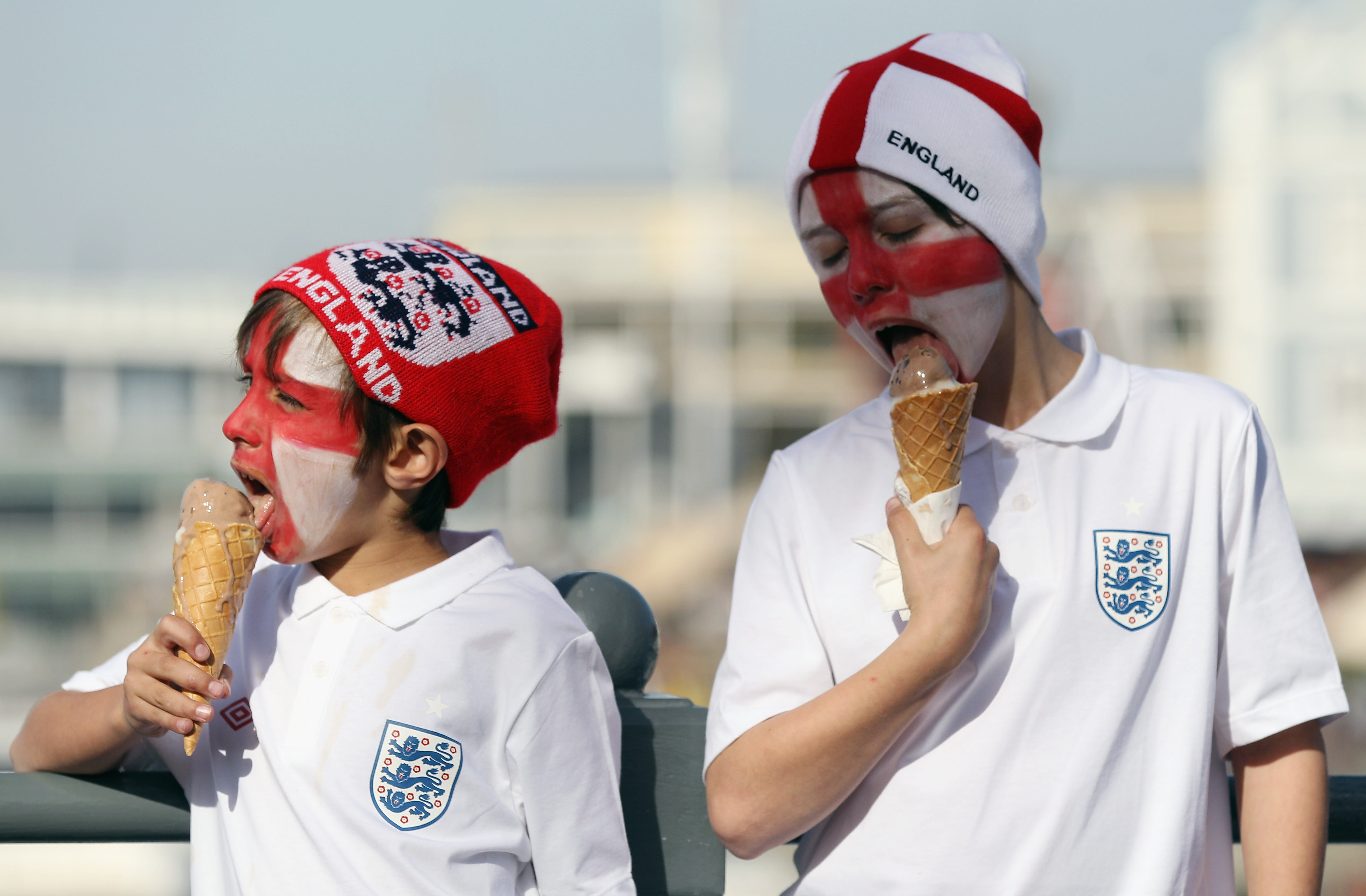 CAPE TOWN, SOUTH AFRICA - JUNE 18:  Two young England football supporters eat ice creams on the Waterfront on June 18, 2010 in Cape Town, South Africa. Cape Town hosts the match between England and Algeria tonight in the second of their group stage matche