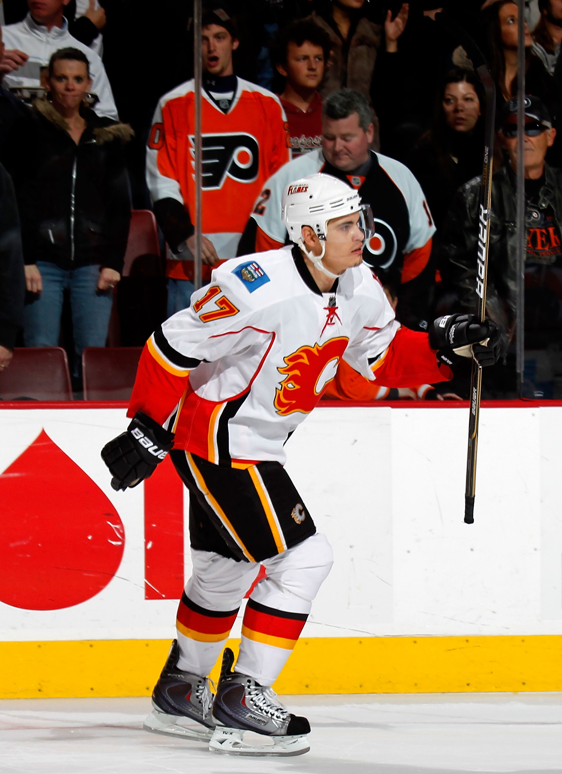 PHILADELPHIA - NOVEMBER 26:   Rene Bourque #17 of the Calgary Flames raises his stick in front of the dejected Flyers fans after scoring the winning goal in the shootout of a hockey game against the Philadelphia Flyers at the Wells Fargo Center on Novembe